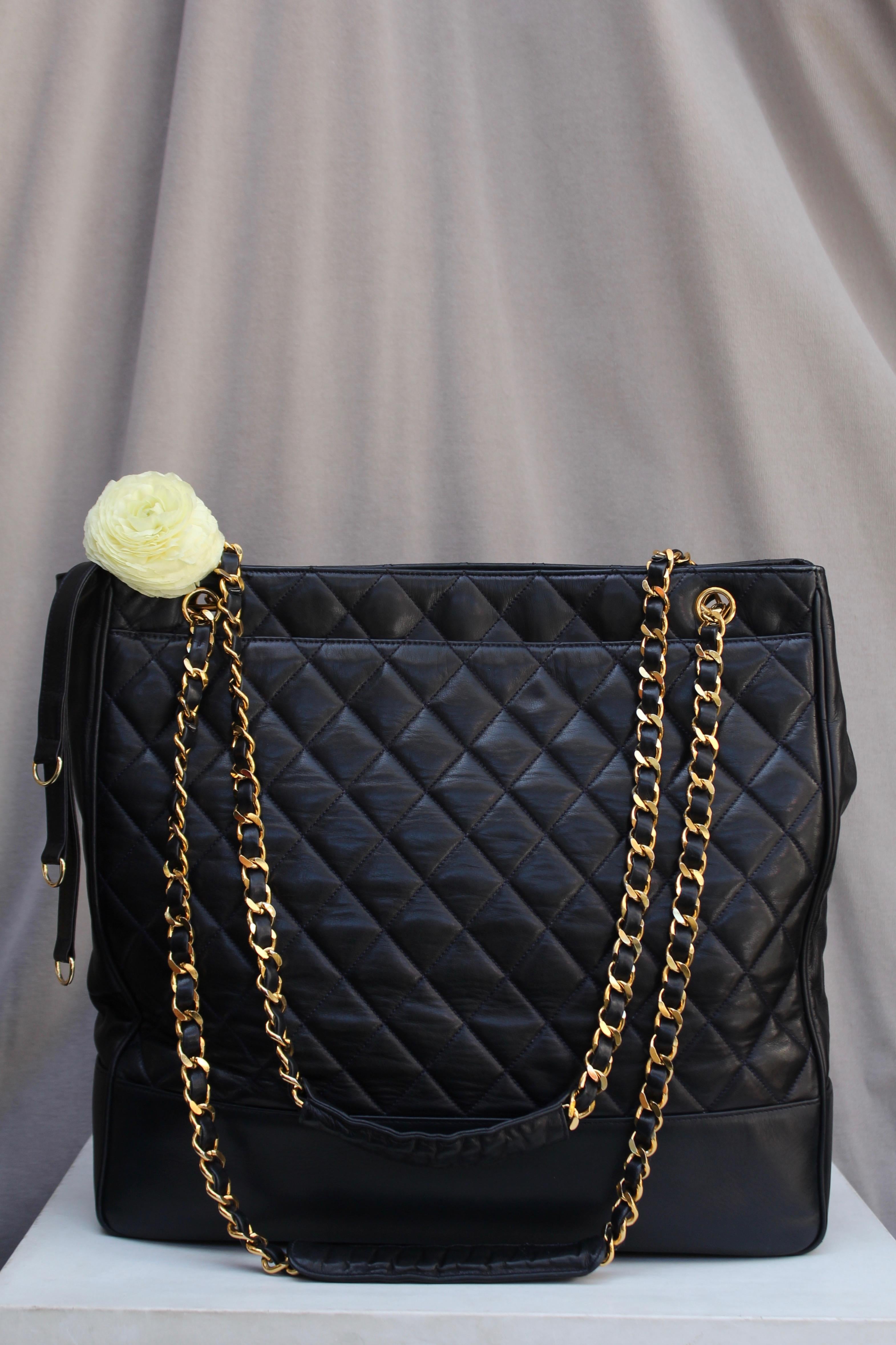 CHANEL (Made in Italy) Great vintage shopping bag in quilted black leather. It features two long gilded metal handles entwined with black leather. In the middle of the handles, a leather yokes provides comfort to the shoulder.

On either side of the