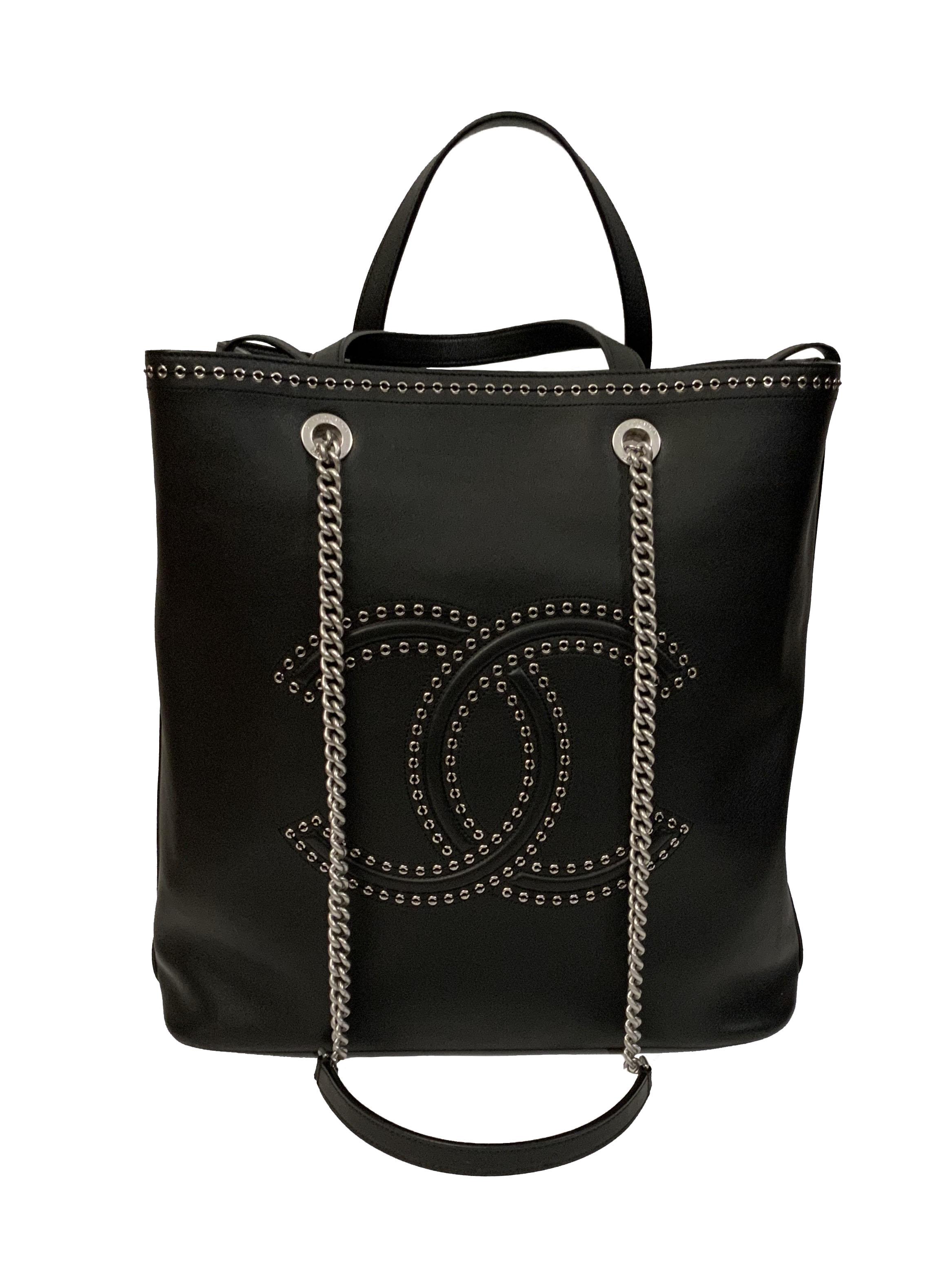 This pre-owned Chanel Large Coco Eyelets Shopping Tote is in mint condition. 
This large tote is crafted in black smooth calfskin leather with silver-tone hardware. 
It features dual flat top handles, dual chain-link shoulder straps, embossed CC