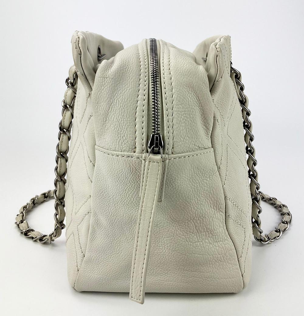 Chanel Large Diamond Stitch Tote in White in very good condition. White leather with large diamond top stitching along both front and back sides. silver hardware and woven chain and leather shoulder straps. 2 exterior side slit pockets. main