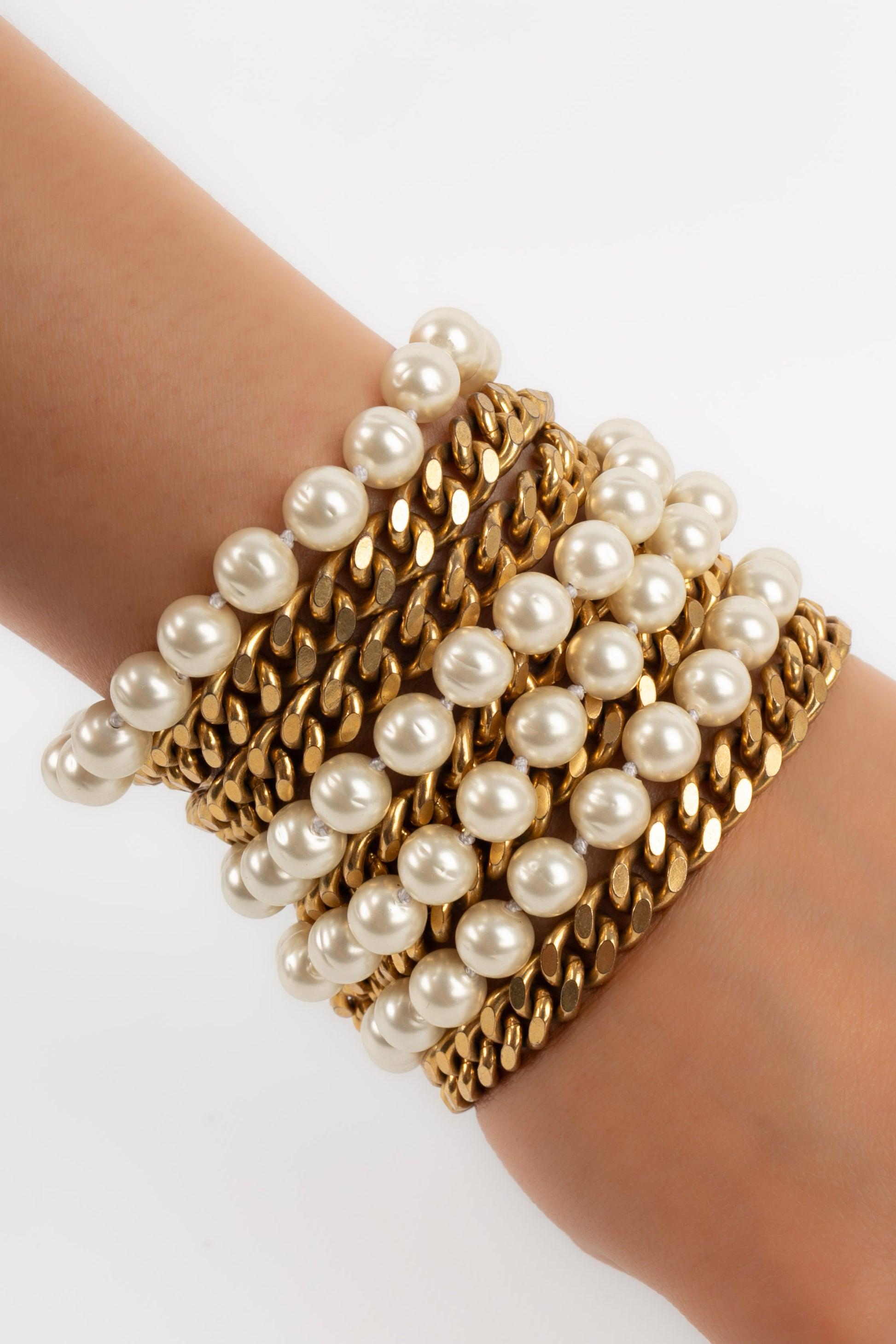Chanel - Large golden metal bracelet with costume pearls.

Additional information:
Condition: Very good condition
Dimensions: Length: 19 cm - Width: 8 cm

Seller Reference: BRAB56
