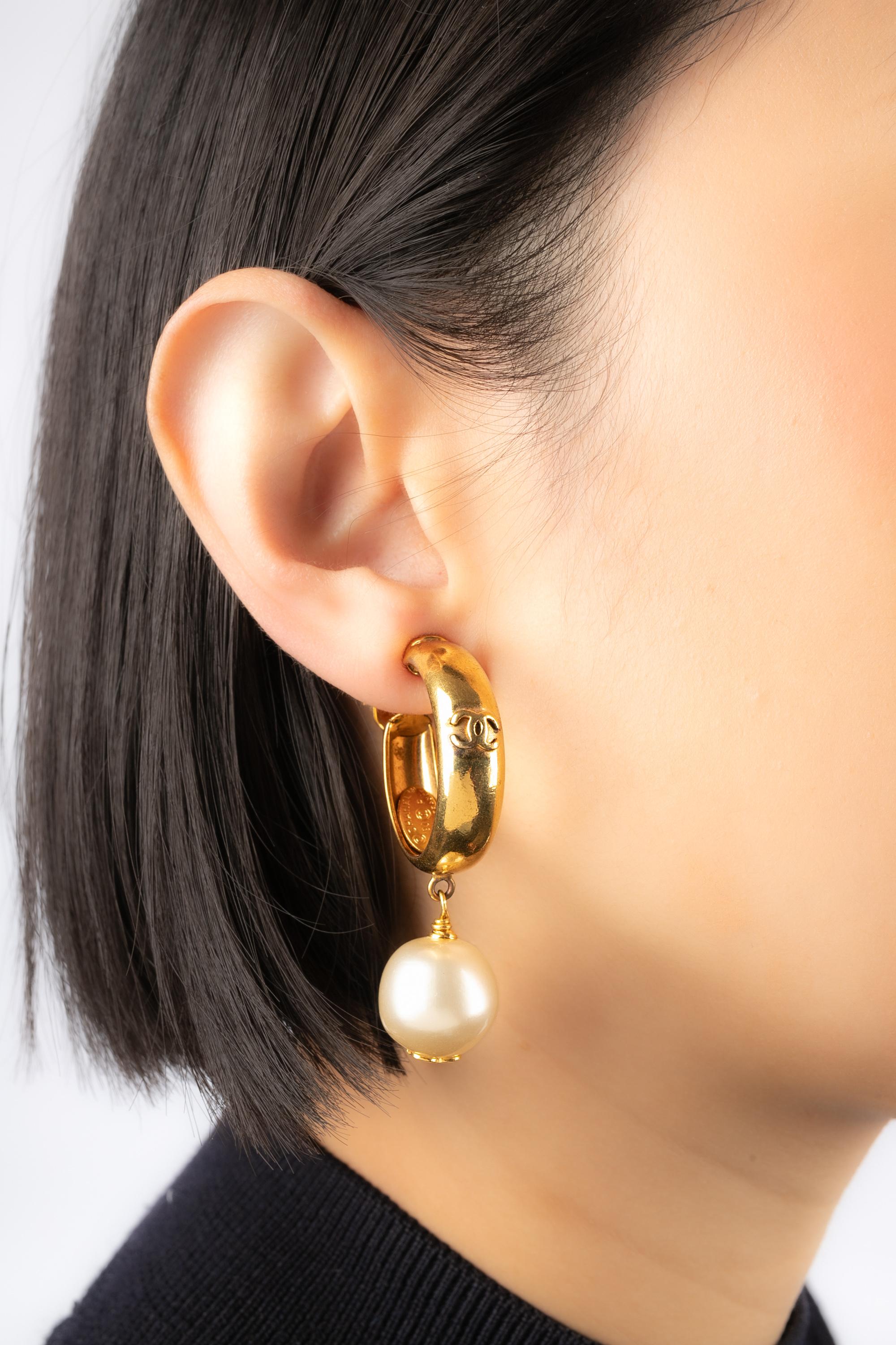 CHANEL - (Made in France) Golden metal clip-on earrings with a large hoop style and a costume pearl. 1993 Spring-Summer Ready-to-Wear Collection.

Condition:
Very good condition

Dimensions:
Length: 5.5 cm

BOB239