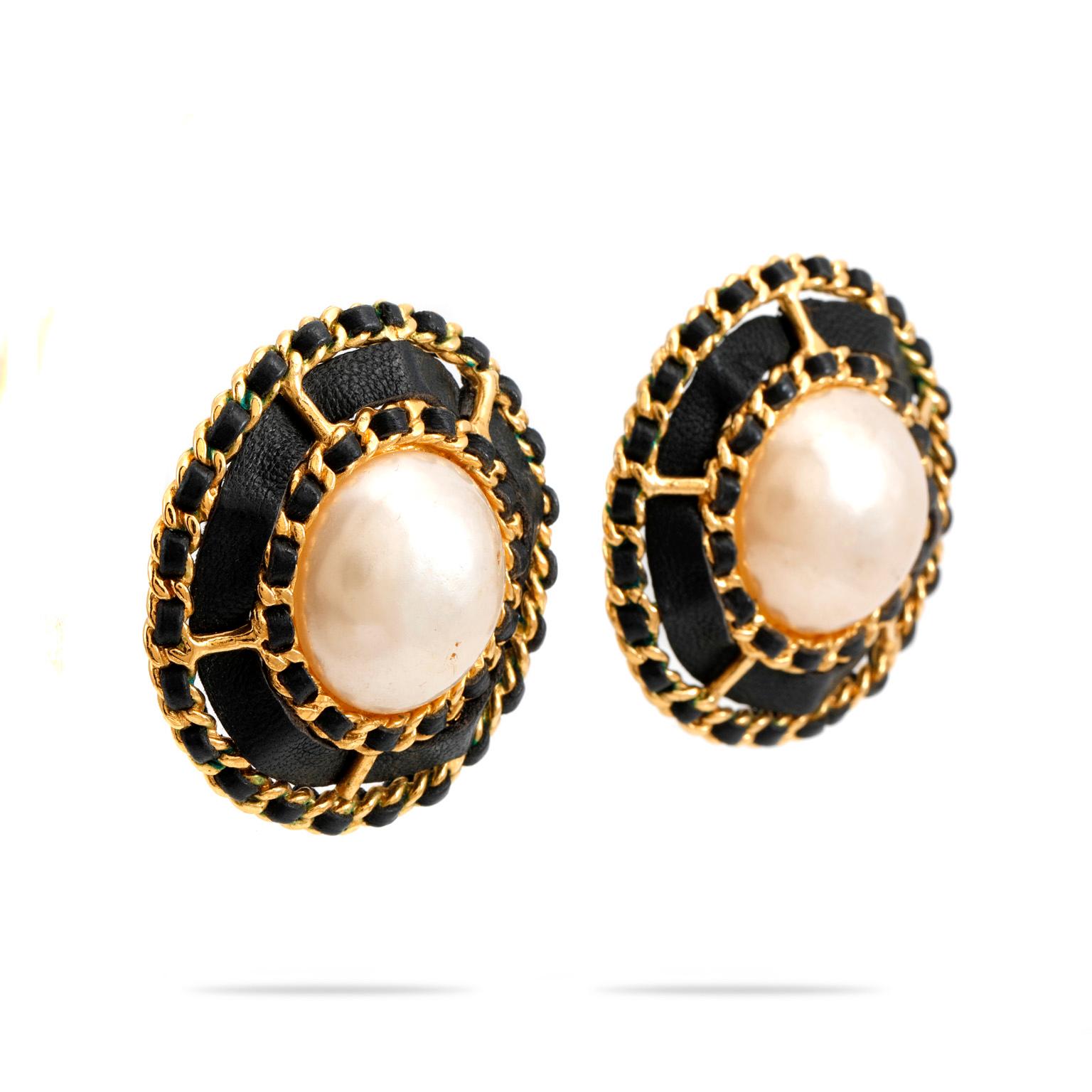 These authentic Chanel Large Pearl Earrings with Leather and Chain Surround are in excellent vintage condition.  Large faux pearl button earrings are surrounded by back lambskin and gold link chain detail.  Classic Chanel.  Clip on style.  Pouch or