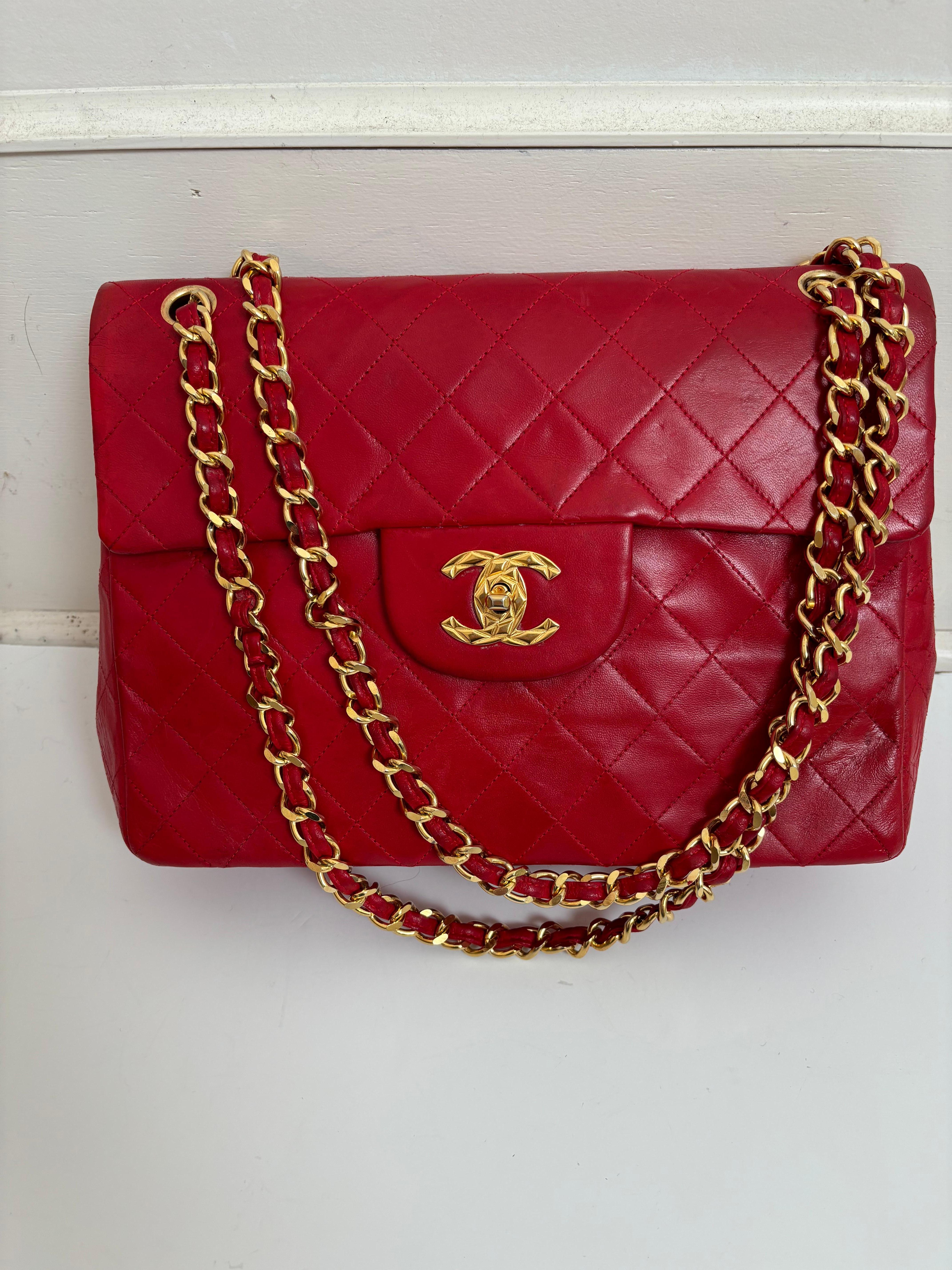 Ce grand sac en peau d'agneau matelassée peut être porté en bandoulière ou à l'épaule. Vintage des années 80, il est doté d'une rare fermeture à verrou CC gravé au diamant, d'une lanière en cuir entrelacé et en métal doré, d'une poche plaquée à