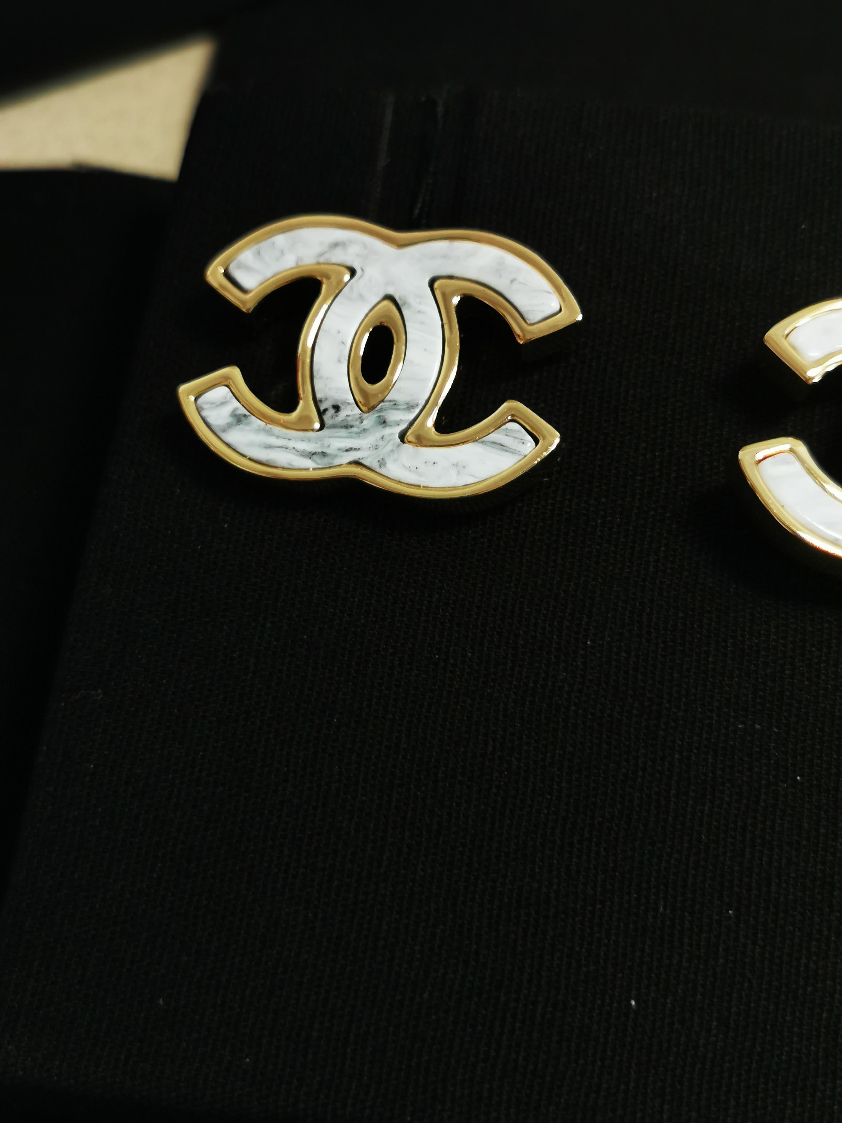 Absolutely! Here's a product description for the Chanel White Marble Enamel Large CC Stud Earrings:

---

Elevate your accessory game with the timeless elegance of Chanel's White Marble Enamel Large CC Stud Earrings. Crafted to perfection, these