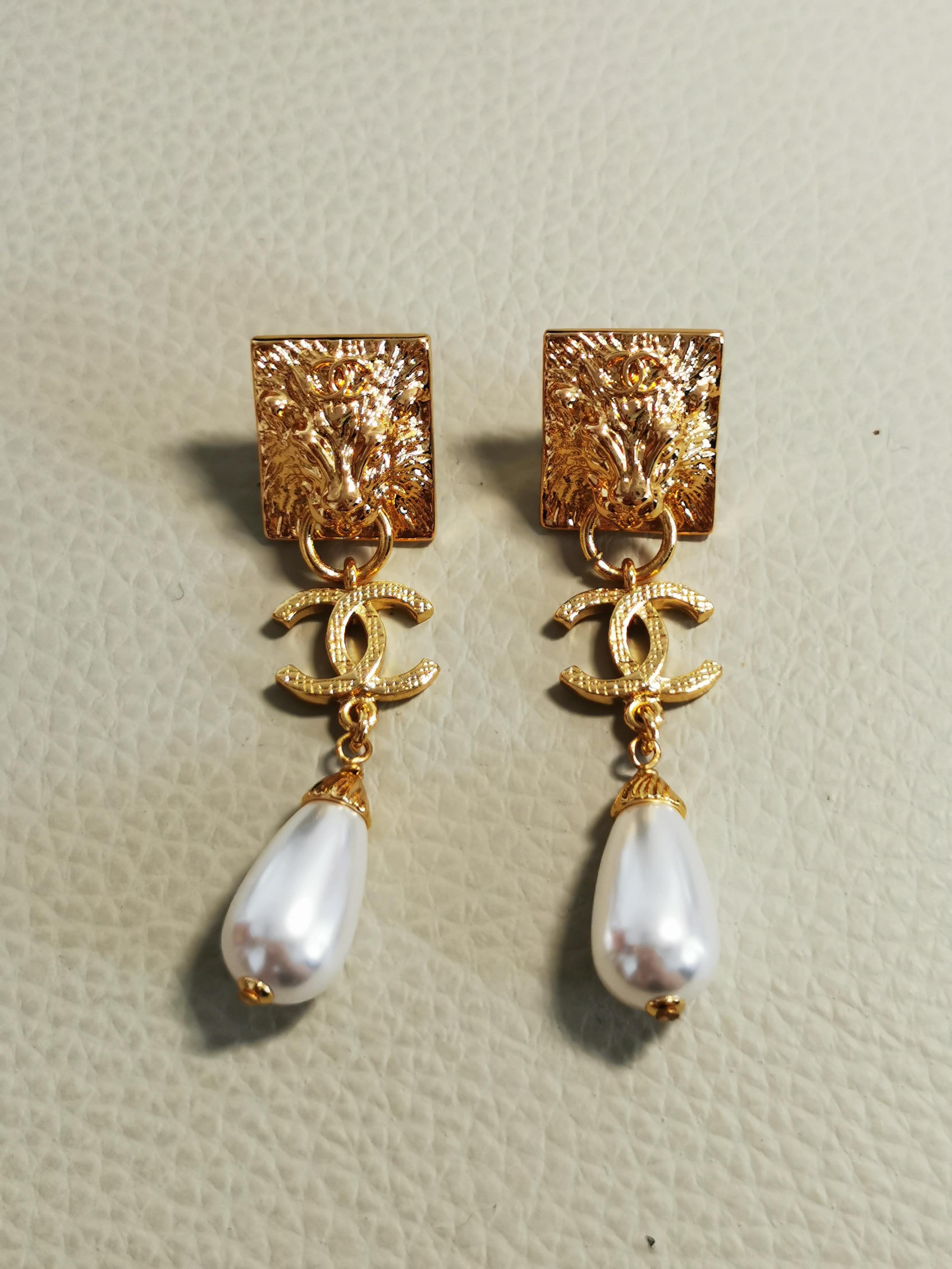 Certainly! Here's a description for the Chanel Lion Head Gold Drop Pearl Long Earrings:

---

Indulge in the regal allure of Chanel with the Lion Head Gold Drop Pearl Long Earrings, a testament to timeless elegance and impeccable craftsmanship.
