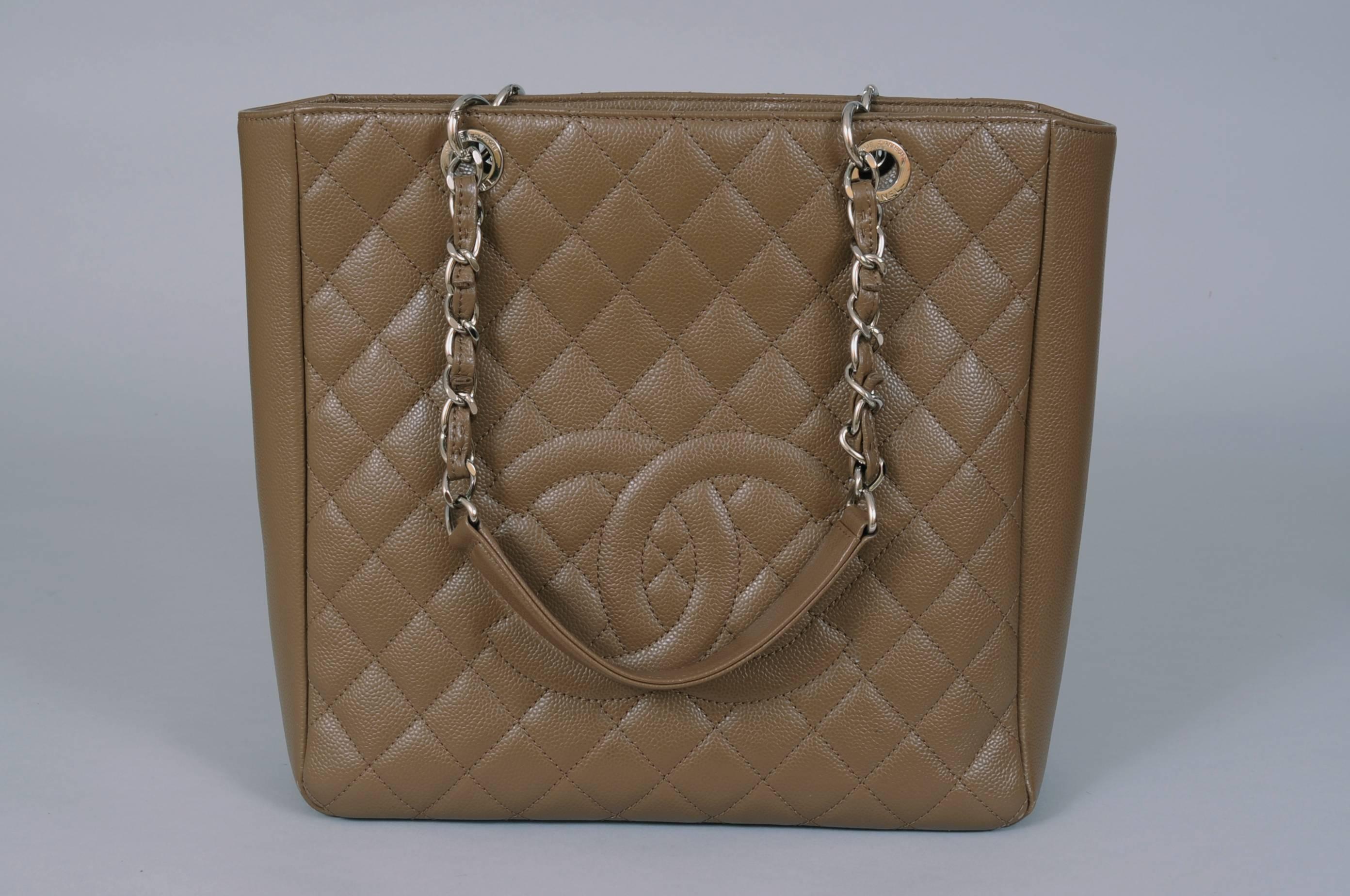 A classic style form Chanel this large tote is in excellent condition inside and out. and it comes with the original receipt from the Chanel Boutique. The bag has double leather and silver toned chain straps, a Chanel logo on the front and a slip