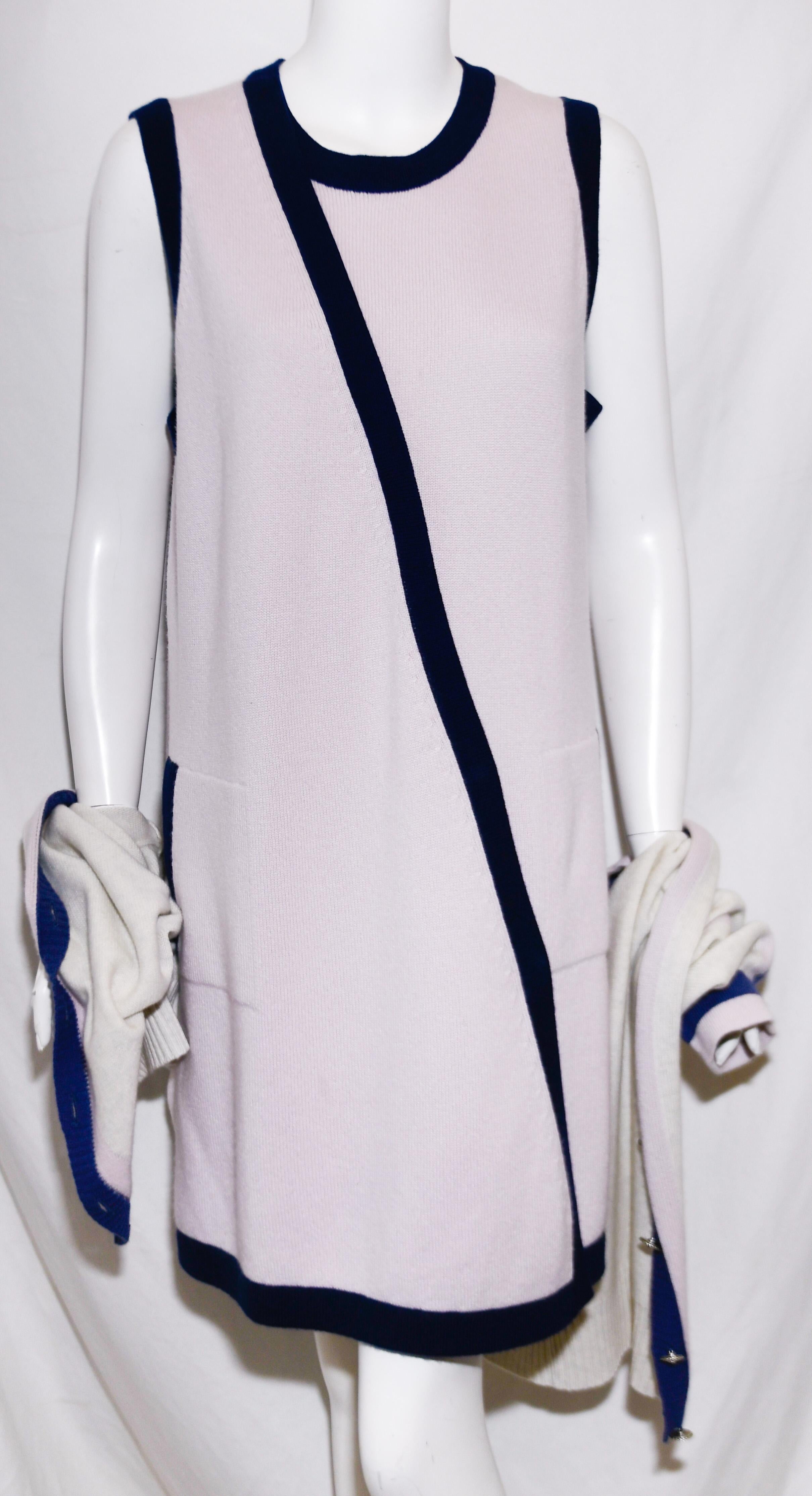 Chanel lavender cashmere dress is accentuated with blue trim around crew neck and hem and, also on band from neckline to hem. Two side slit pockets, one with the classic CC blue gripoix button.  The beige cardigan includes a lavender and purple trim