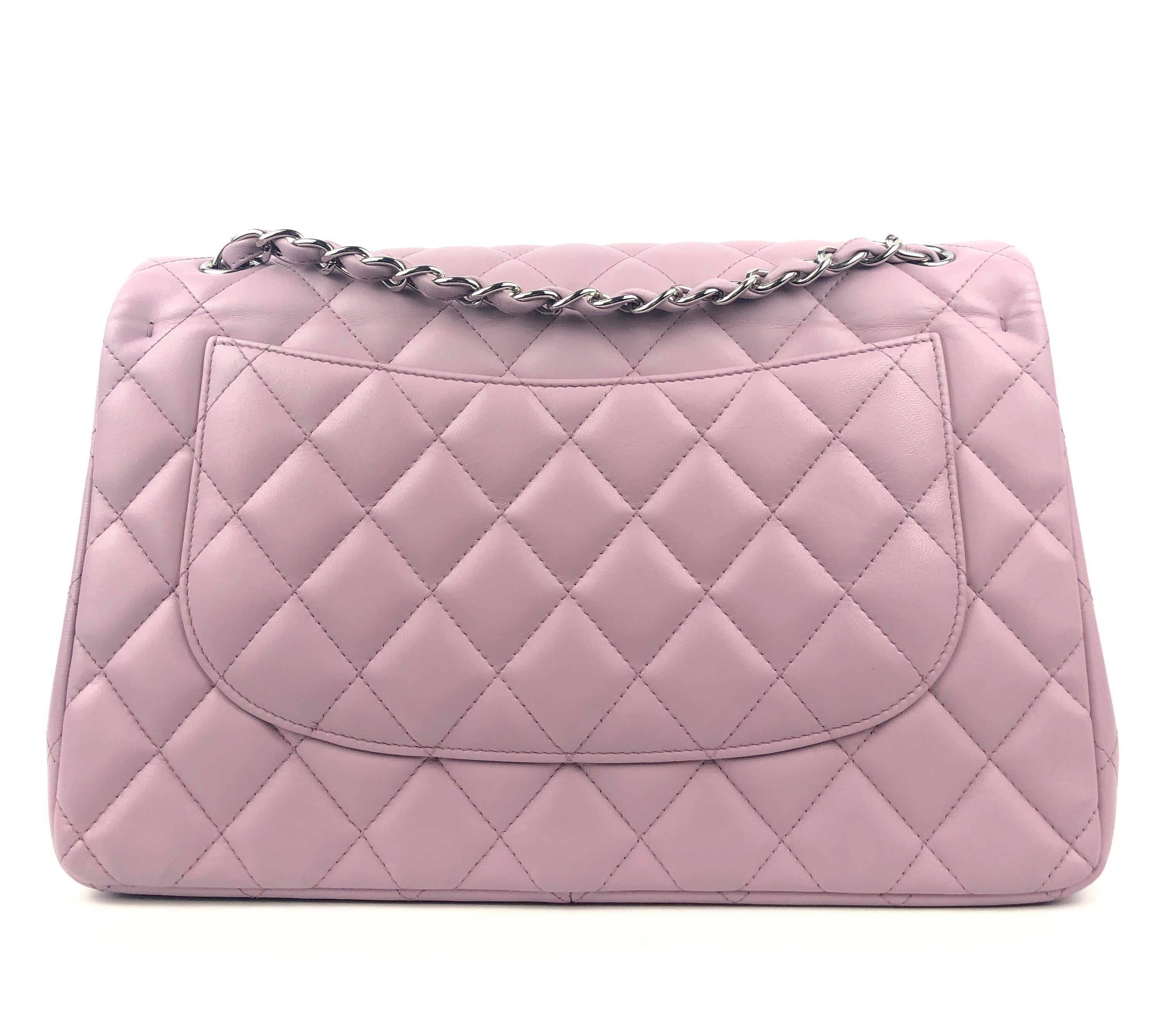This authentic Chanel Lavender Lambskin Jumbo Classic Flap is in pristine condition.  The highly sought after Jumbo Classic is breathtaking in this feminine shade of soft lavender.
Quilted lambskin with silver tone interlocking CC twist lock on