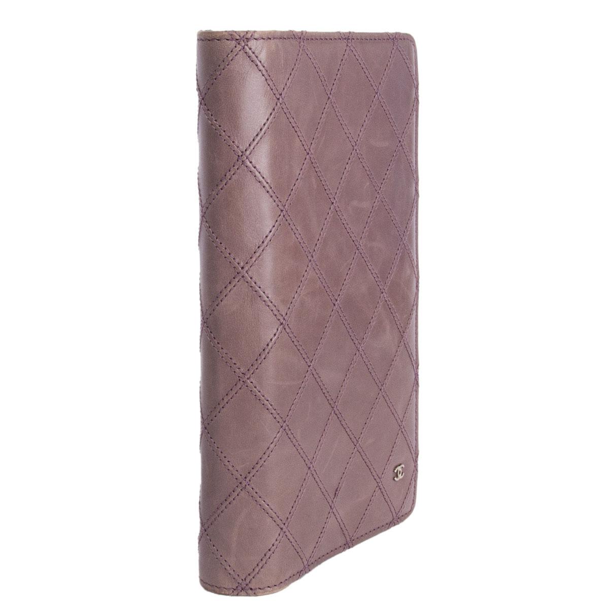 100% authentic Chanel quilted long flap wallet in lavender smooth leather. Contains 8 card slots and five open compartments with one zipper coin pocket. Has never been carried however the outside leather has a soft  discoloration compared to the