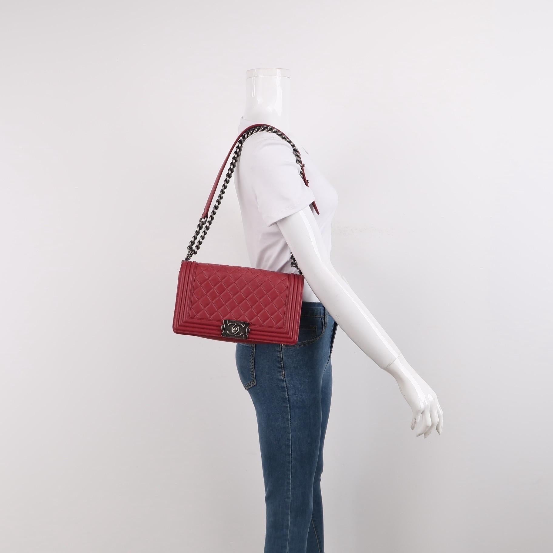 Constructed from black lambskin and adorned with silver gunmetal chains, this Chanel Enchained Boy Bag boasts both style and functionality. The iconic boy lock and famous Chanel Diamond quilting adorn the exterior, while the interior offers ample