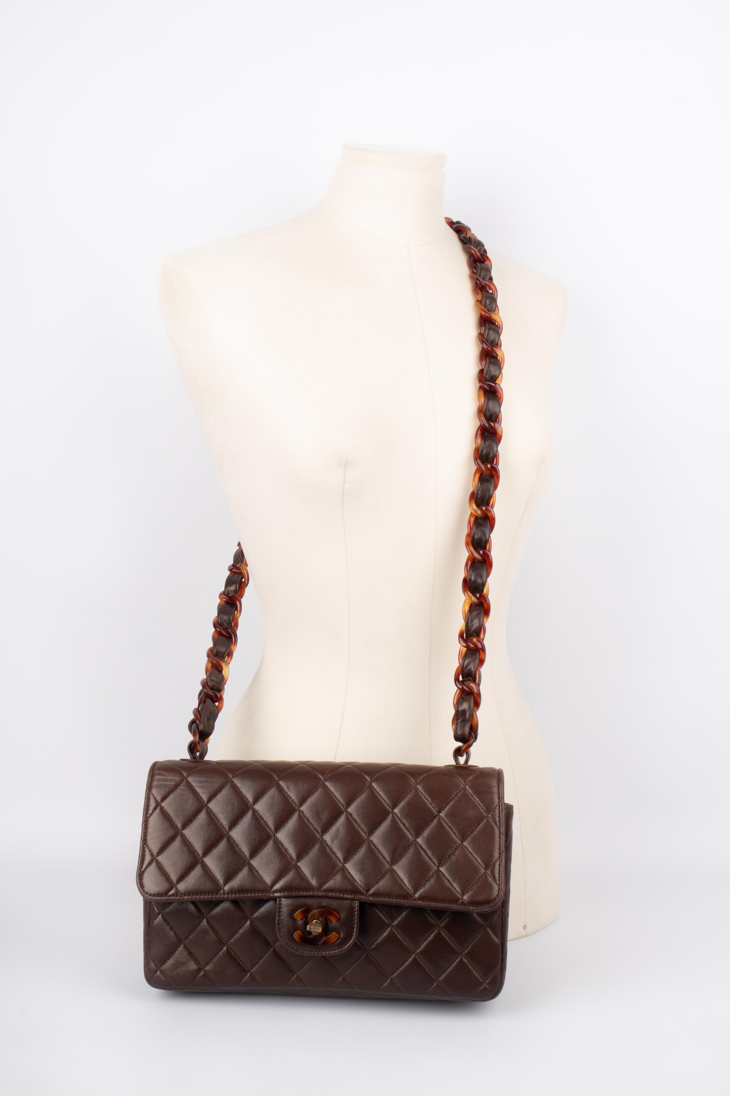 CHANEL - (Made in France) Brown leather quilted handbag. Bakelite clasp and handle. Authenticity card and serial number 3011841.

Condition:
Good condition

Dimensions :
Width: 26 cm - Height: 17 cm - Depth: 7 cm

S143