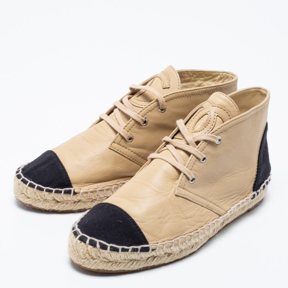 Les chaussures de sport sont le meilleur moyen de profiter d'un confort et d'un luxe absolus. Ces espadrilles de Chanel sont à la fois robustes et élégantes. Confectionnées en cuir beige et en toile noire, elles présentent des fermetures à lacets,