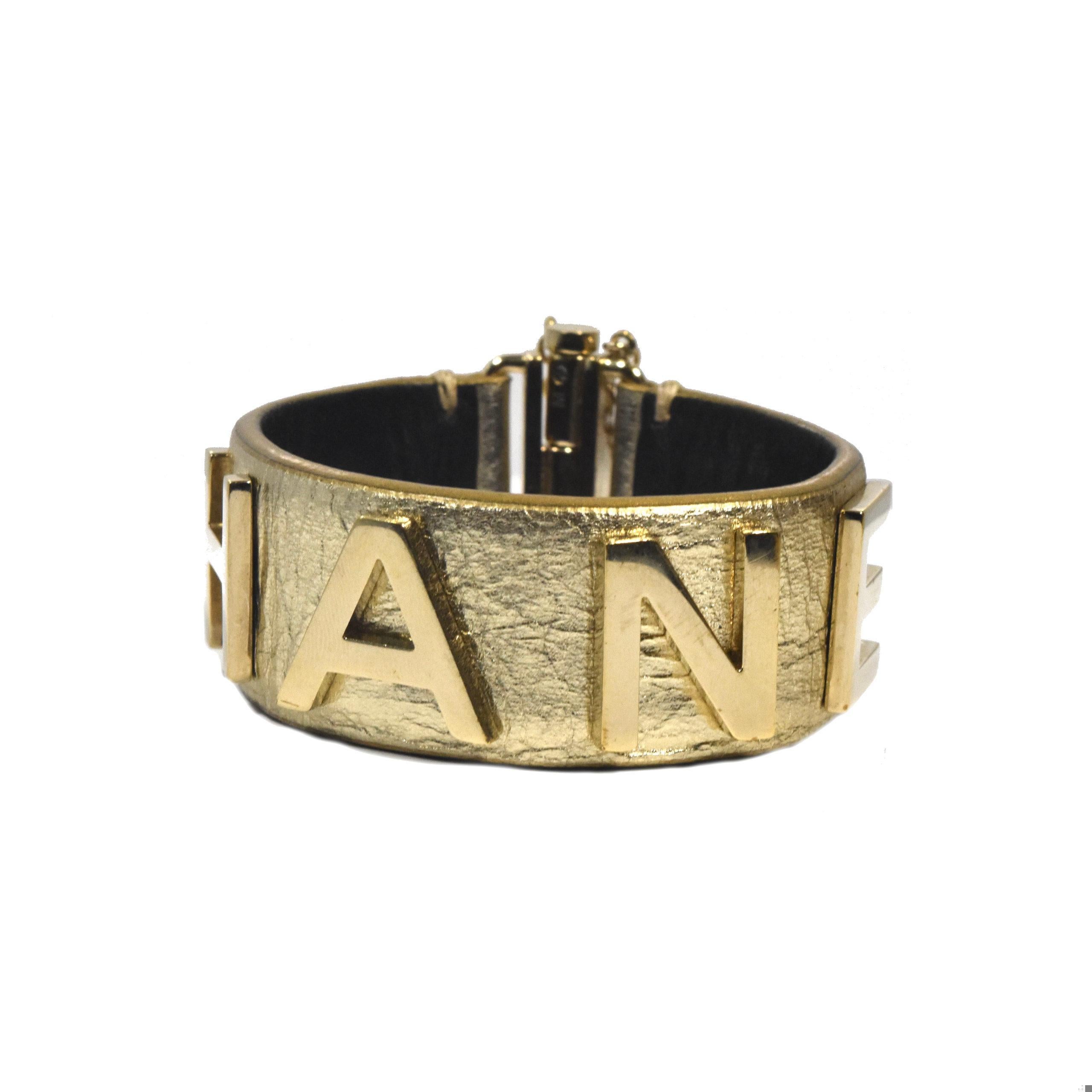 Bold look for this pre-owned gold calfskin leather bracelet accented by large gold hardware. The Chanel logo is big and nicely fit on the bracelet. There is a slide lock closure. This timeless piece was gently worn and is in good condition. This