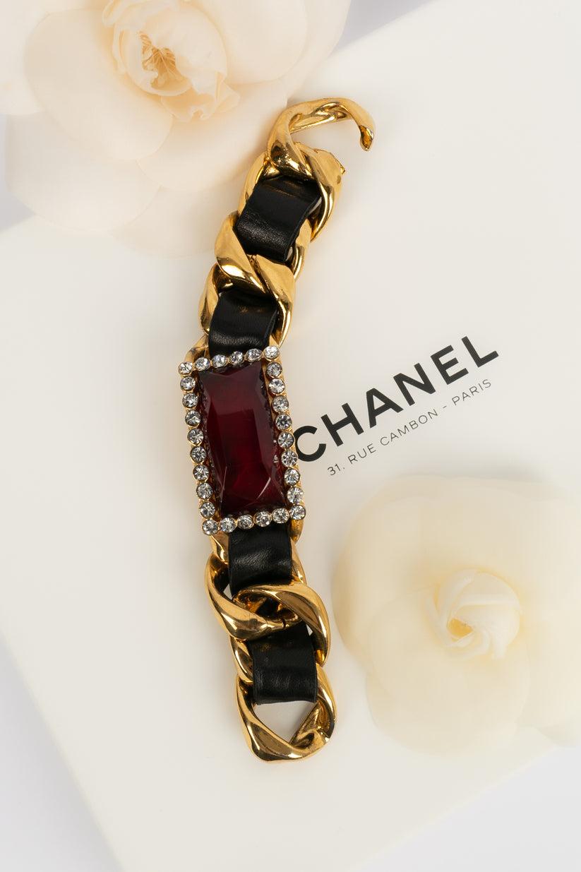 Chanel - (Made in France) Bracelet gourmette en métal doré, cuir noir, strass rouge et strass Swarovski. Collection 2cc4. 
Jewell gravé avec le S de vente.

Informations complémentaires :

Dimensions : Longueur : 19 cm
Largeur : environ 3 cm

Condit