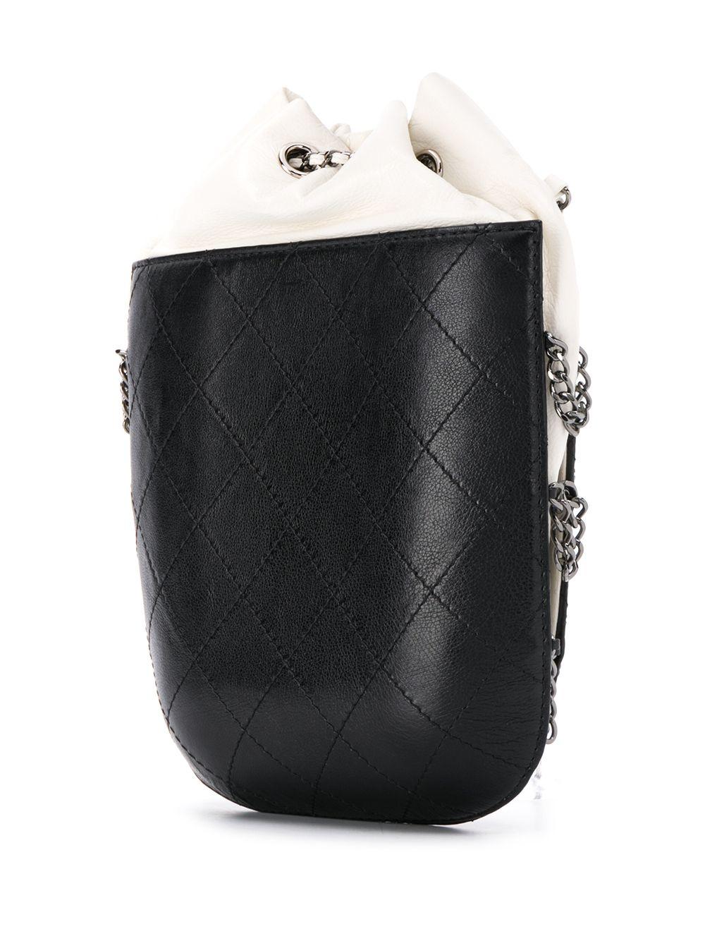 Crafted in France, this Gabrielle crossbody purse from the Chanel Spring/ Summer 2017 Collection showcases a contrasting combination of aged and smooth supple white calfskin Leather at the top, and structured, diamond-quilted black Caviar leather