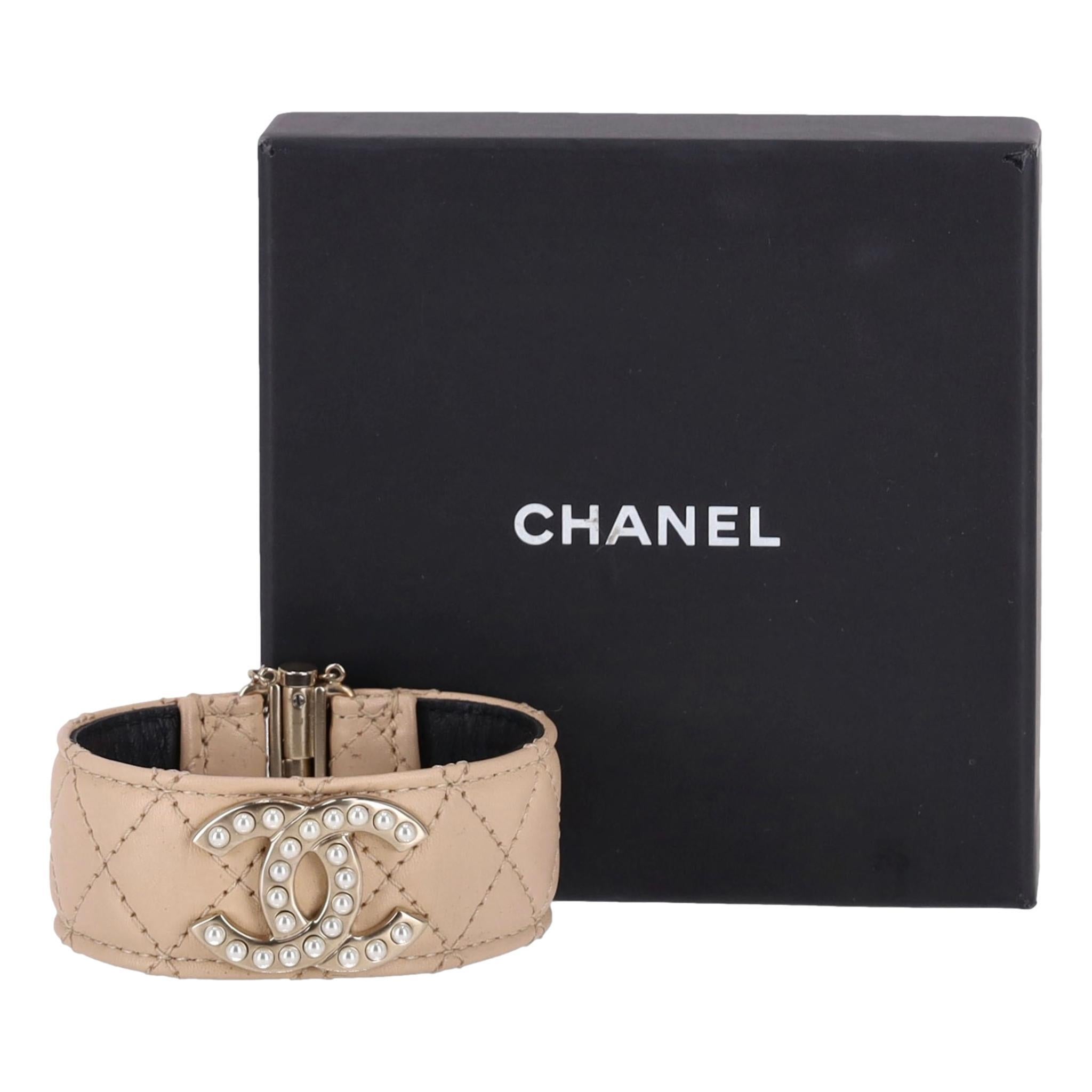 Oggetto raro - Bracciale in pelle Chanel con logo 'CC' in perla

Bracciale beige in pelle liscia con cuciture a rombi.

Il logo 