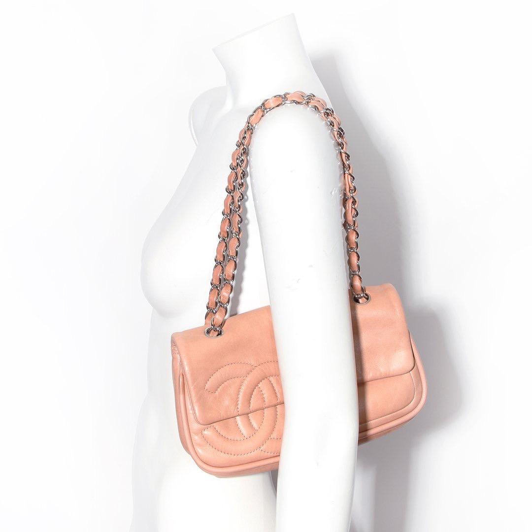 Leather flap bag by Chanel
Circa 2006-2008 
Pink leather
Snap-flap closure 
One exterior back pocket 
Two interior slip pockets
One interior zip pocket
Silver-tone hardware 
Leather and chain strap 
Exterior Stitching of Iconic “CC” Logo
Condition: