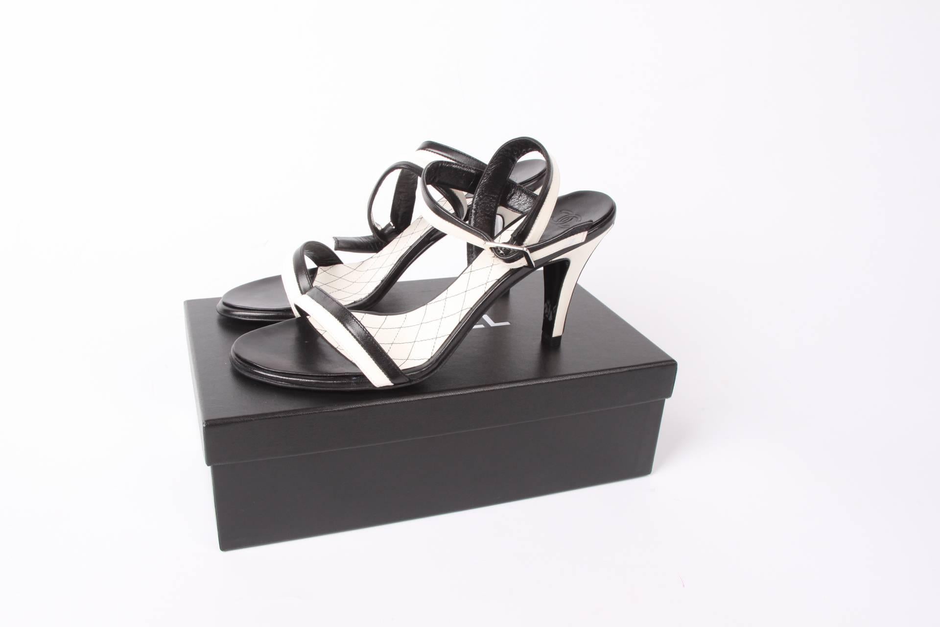 Stylish pair of high heeled shoes by Chanel in a classic colour combination of black and white leather.

A 2 centimeters wide leather strap around the ankle in black and white with square silver-tone buckle, a black & white strap across the toes and