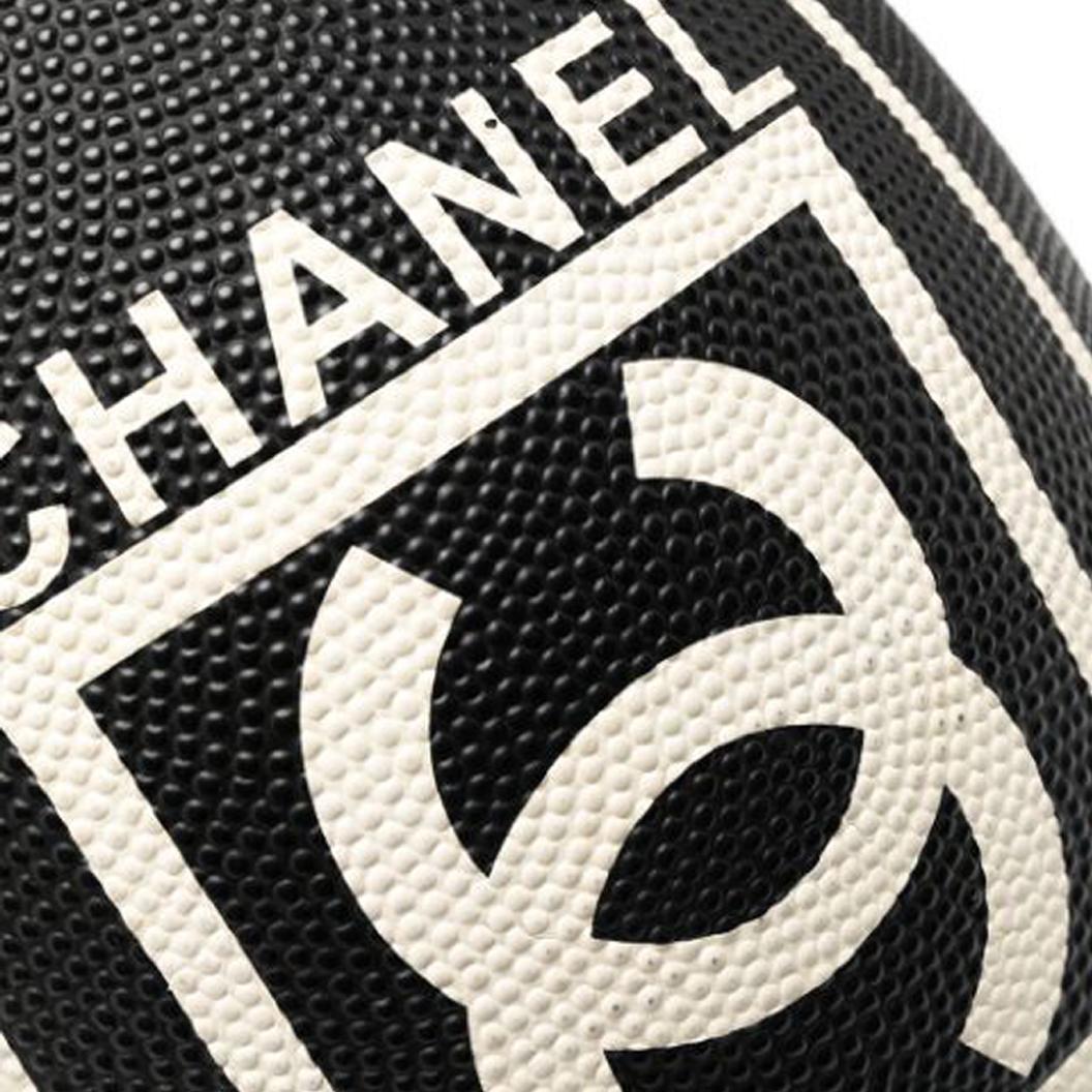 Ballon de rugby en édition limitée de 2007, fabriqué en caoutchouc synthétique noir anthracite, ce ballon de rugby en édition limitée de Chanel présente le logo CC emblématique de la marque au centre, des détails contrastés de couleur blanc cassé et