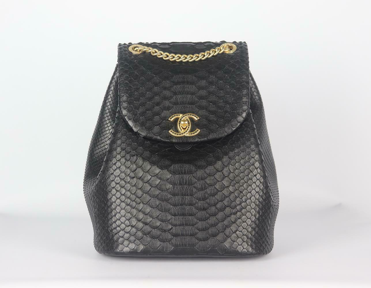 Made in Italy, this beautiful Chanel backpack has been made from black python and leather exterior with black leather interior, this piece is decorated with Chanel's antiqued-gold embroidered twist-lock logo on the front and finished chain top hand