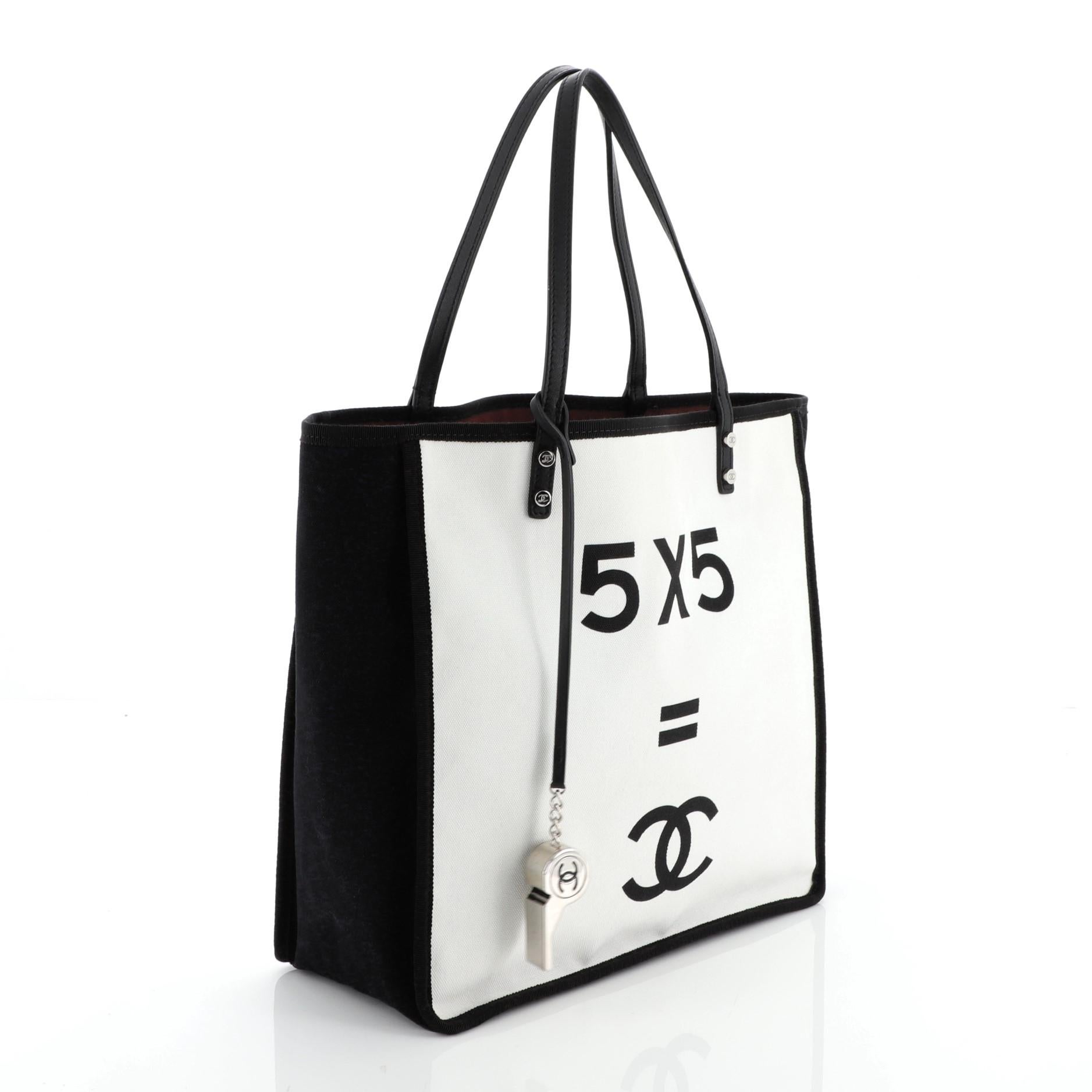 This Chanel Let's Demonstrate Tote Canvas Small, Crafted in white and black canvas, features calfskin leather strap top handles and silver-tone hardware. Its wide open top showcases a red fabric interior with snap pockets. Authenticity code reads: