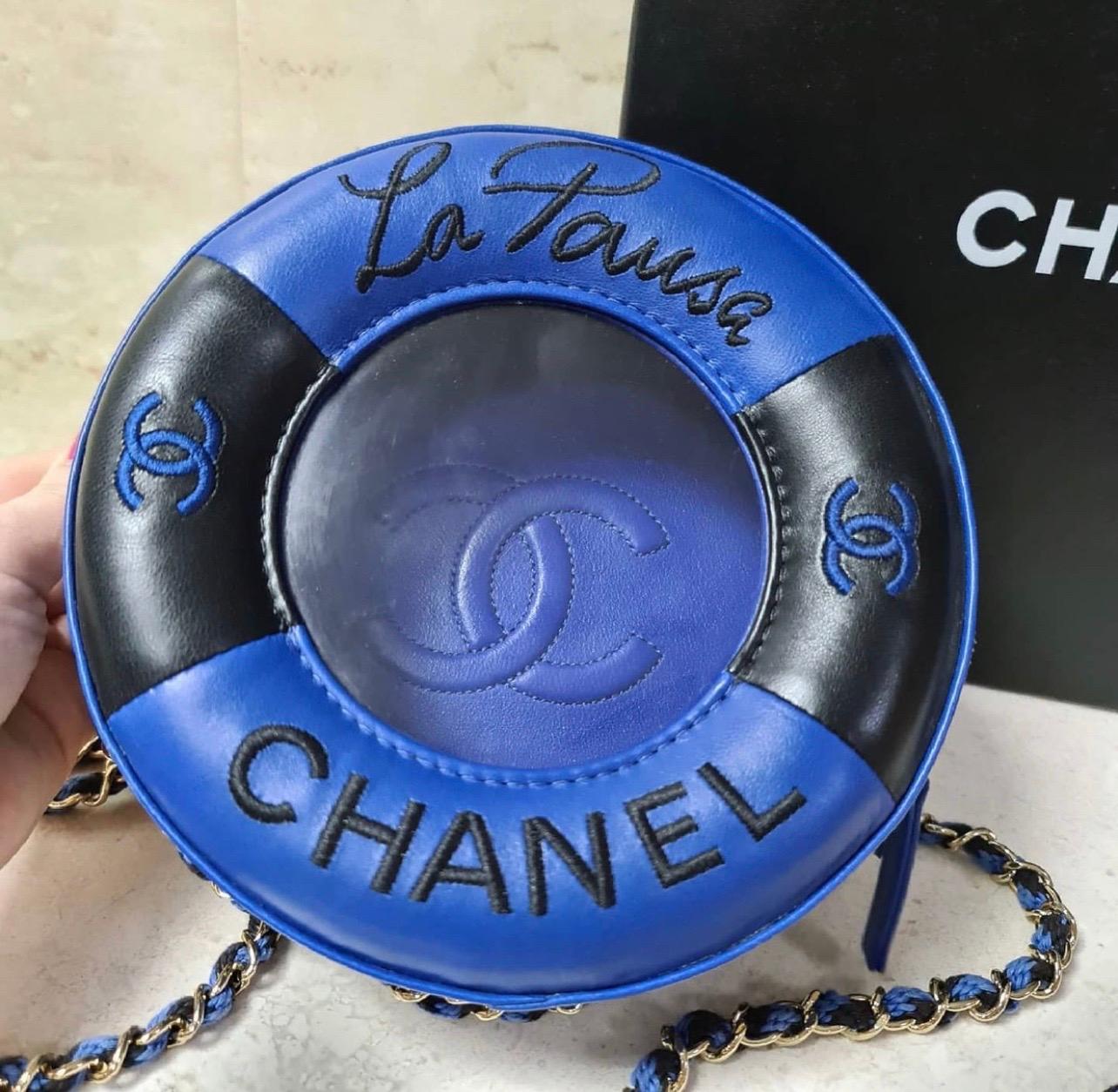 This Chanel Lifesaver Round Crossbody Bag Lambskin, crafted from black and blue leather, features woven-in canvas chain link strap with shoulder strap and gold-tone hardware.
Its zip-around closure opens to a blue leather interior. 

Condition: