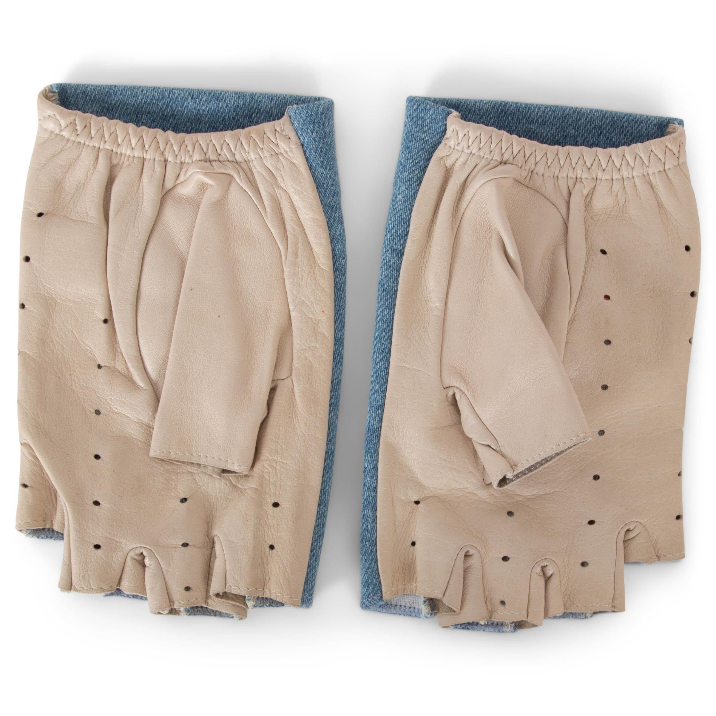 Ces gants sans doigts 100% authentiques de Chanel en denim bleu clair et cuir beige sont un mélange chic d'élégance décontractée et de détails emblématiques. Dotées d'un relief en camélia et d'un logo CC en métal sur le dessus, elles incarnent le