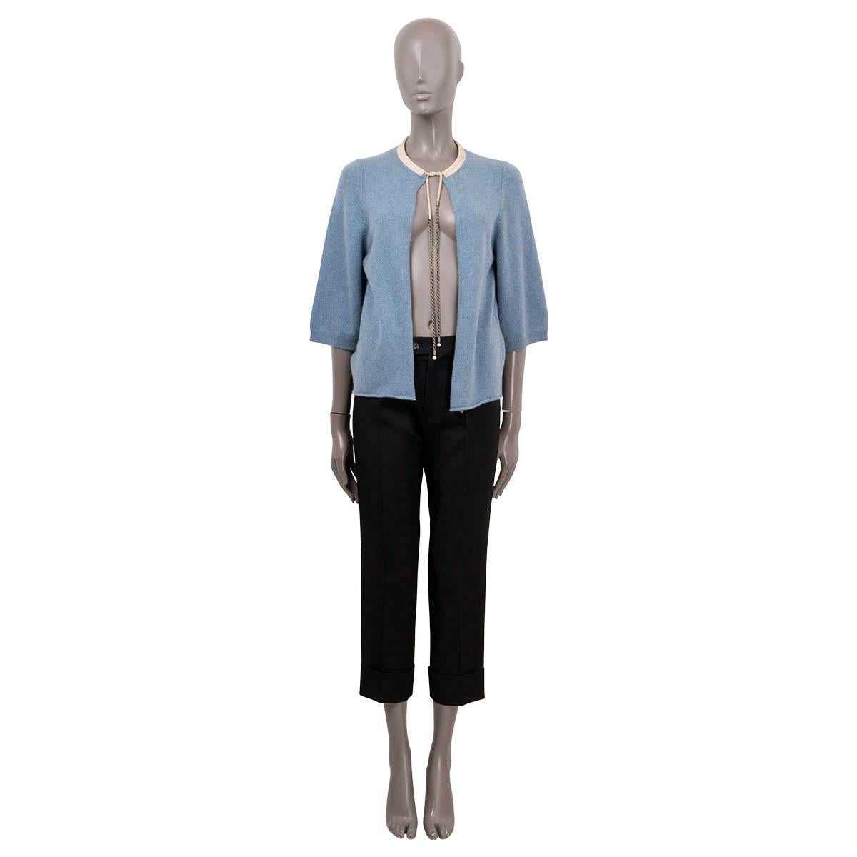 100% authentic Chanel open cardigan in light blue cashmere (100%). Features a round neck and 3/4 sleeves. Closes with a drawstring neck chain on the front in beige and metal. Has been worn and is in excellent condition.

Chanel