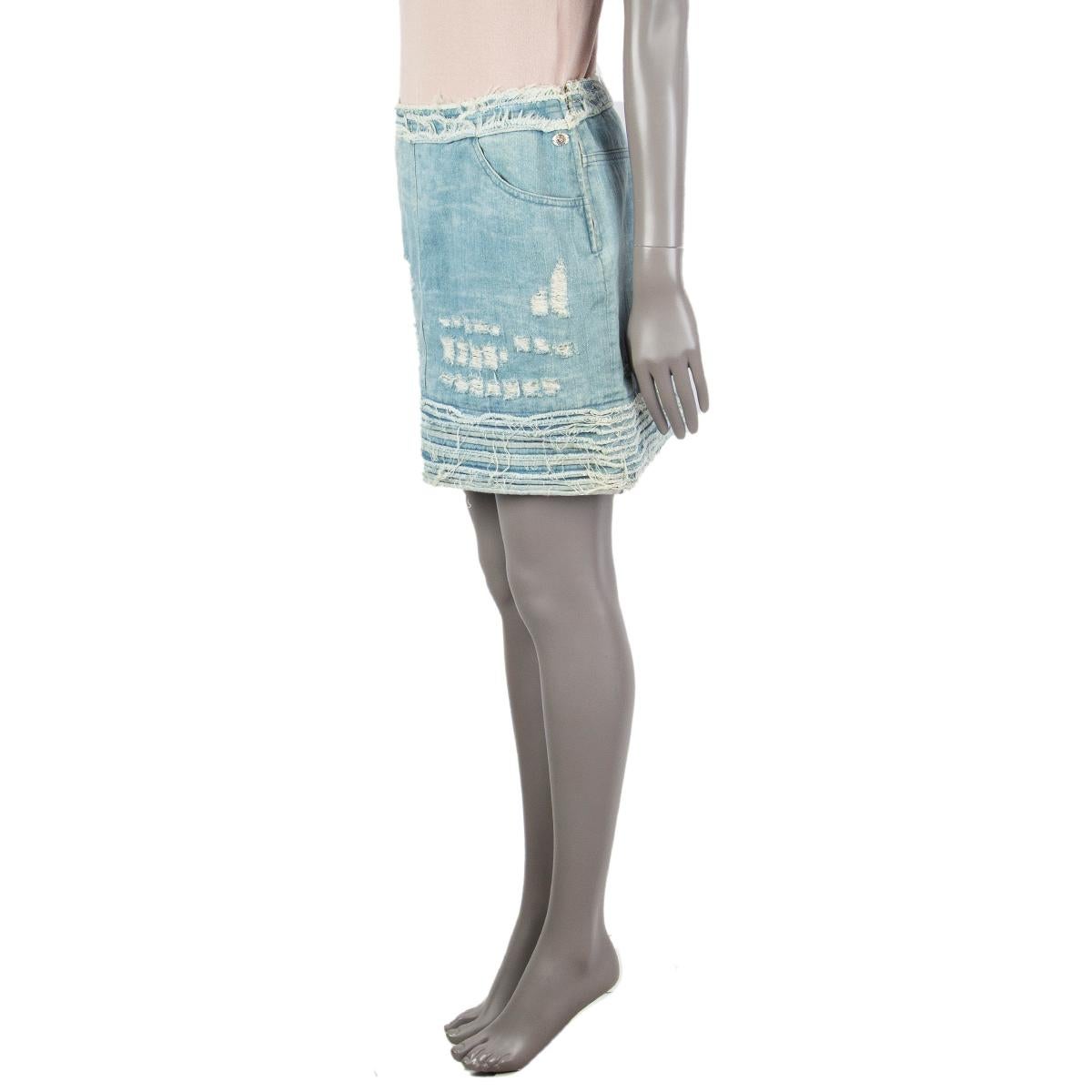 Chanel distressed denim skirt in washed denim cotton (92%) elastane (3%) viscose (3%) polyester (2%) with a straight cut, two pockets and a coin-pocket in the front, trimmed seams and on the left side a small plate stitched on with a lion head.