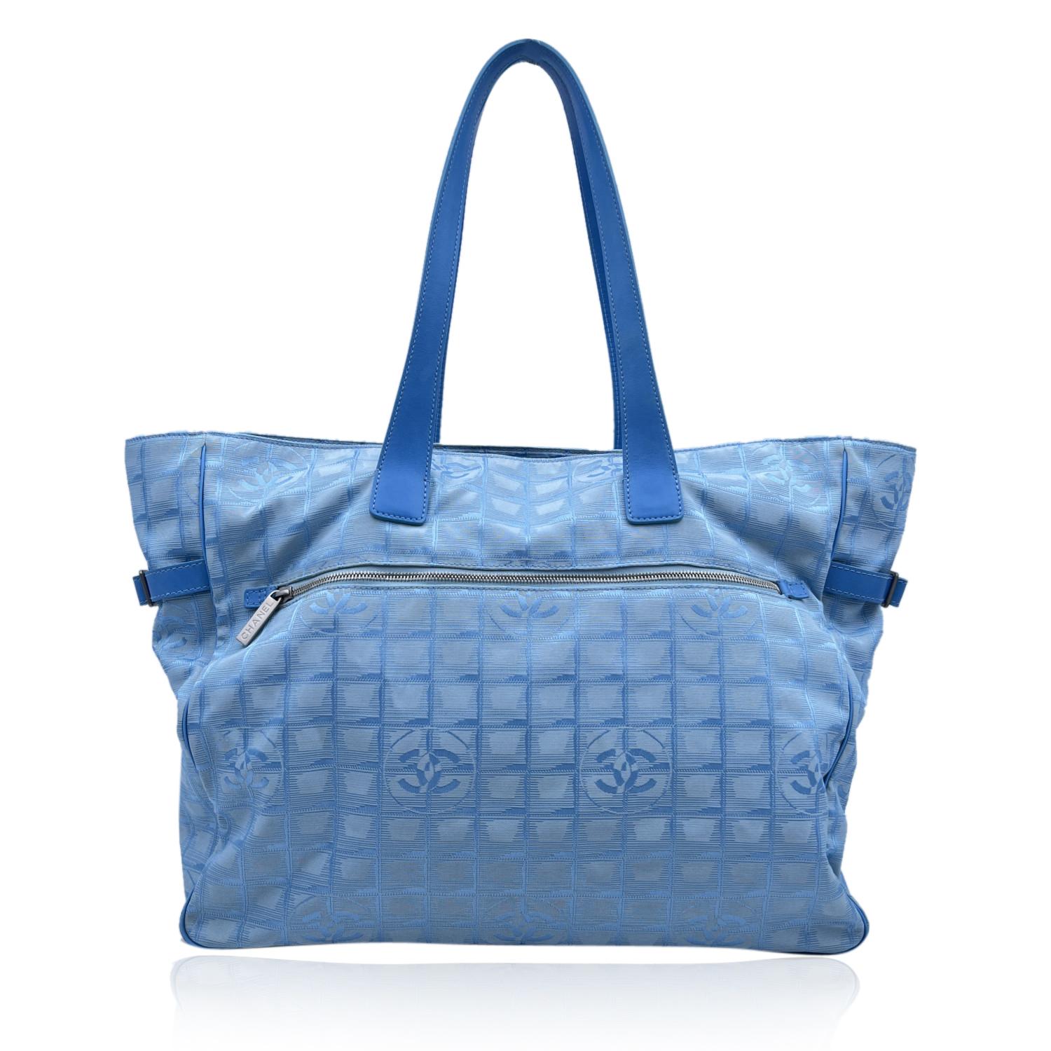 Chanel light blue jacquard nylon tote bag from the 'Travel line' collection. Light blue leather top handles. 1 rear zip pocket. Signature trim on the upper part of the bag. Nylon lining with 2 side zip pockets inside. 'Chanel - Made in France' tag ,