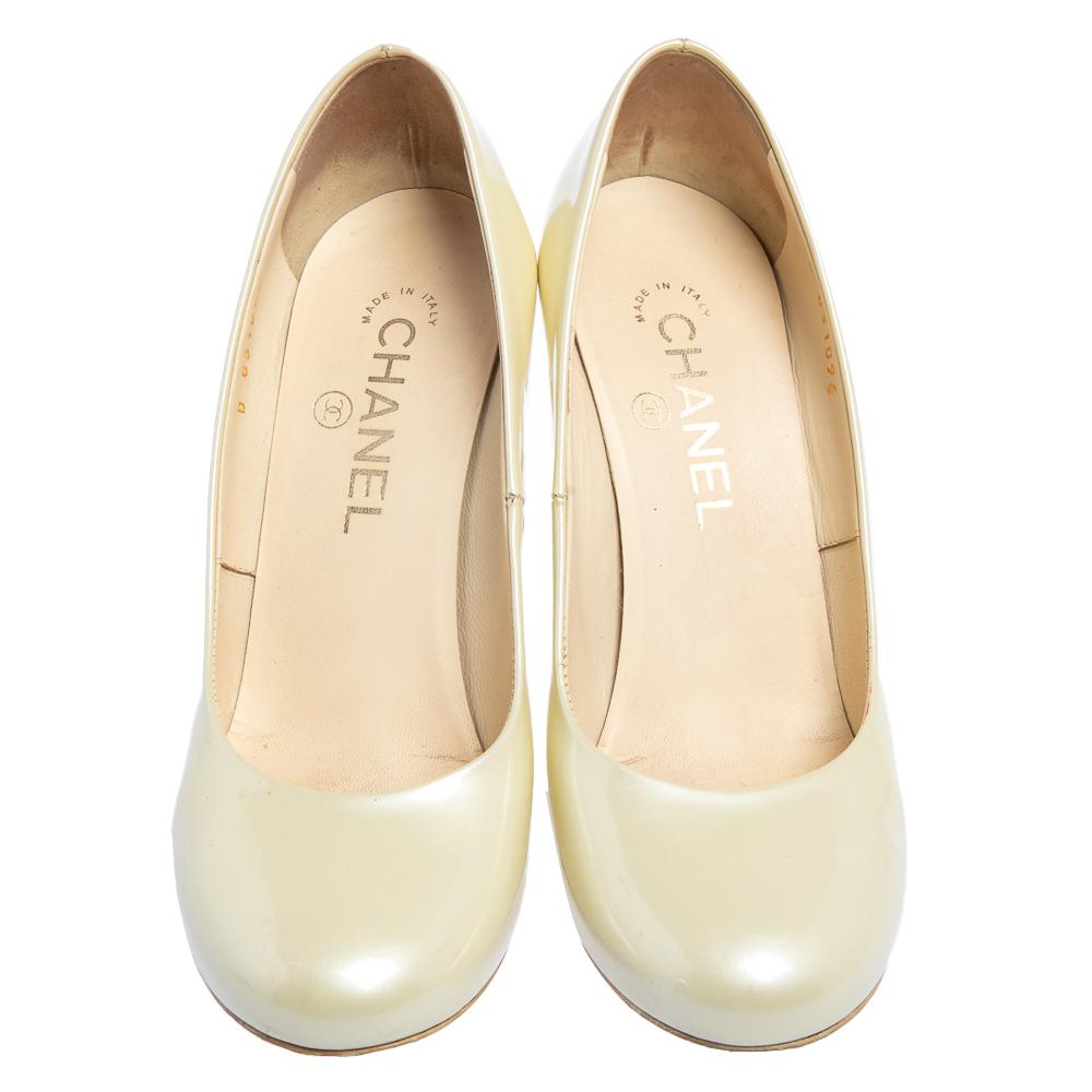 These fabulous pumps from Chanel will lend a luxurious appeal to your looks. They are crafted from patent leather in a light cream shade and feature round toes and the iconic CC logo detailing on the counters. They come equipped with comfortable