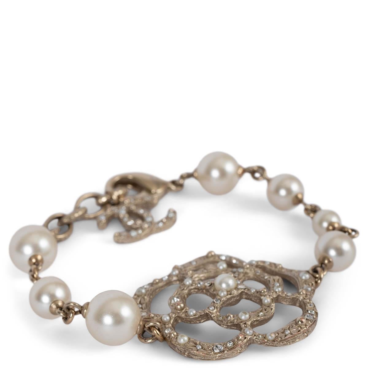 Bracelet Chanellia 100% authentique en métal doré léger avec fausses perles blanches en nacre et Camélia incrusté de cristaux et de perles. A été porté et est en excellent état. Livré avec boîte. 

Collection 2014