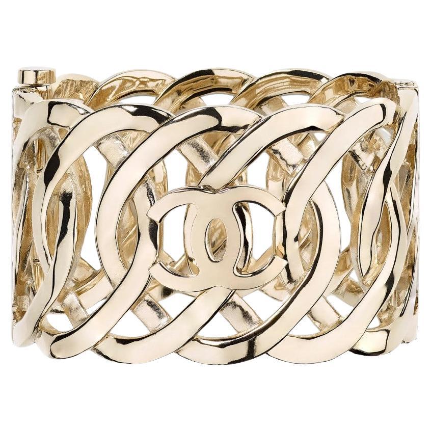 CHANEL Hellgoldenes verflochtenes CC-Logo breites Manschettenarmband