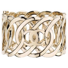 CHANEL Hellgoldenes verflochtenes CC-Logo breites Manschettenarmband