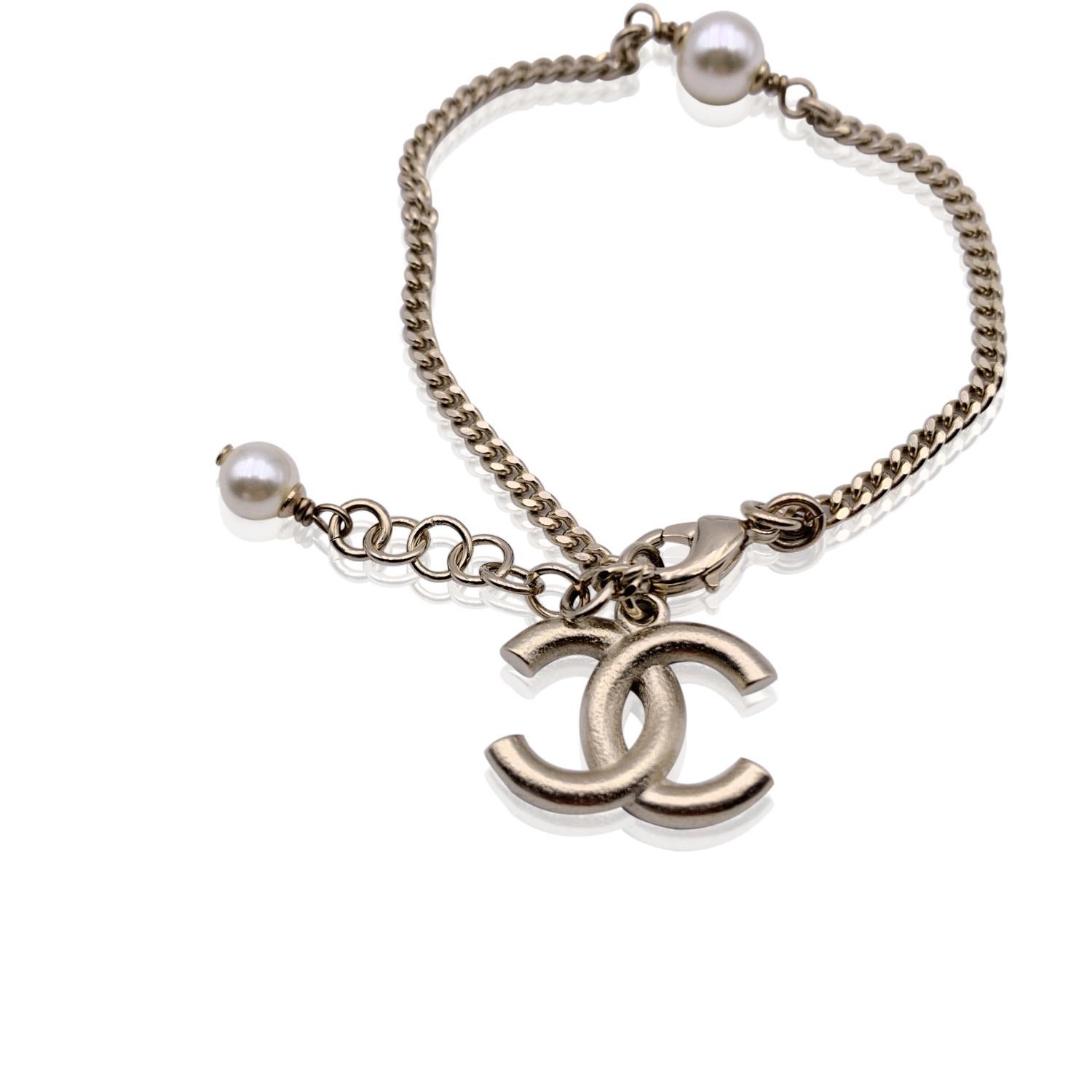 Lovely light gold metal chain bracelet with enameled CC logo charm in black and red, by CHANEL from the 2018/2019 collection. 2 small faux pearls accents. Lobster closure. Marked 'Chanel C18 CC A made in France' on the closure Total lenght: 7.5