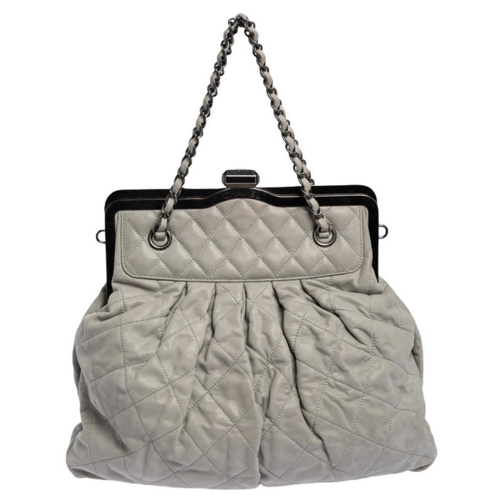 A bag to delight both Chanel lovers and handbag admirers is this one. It is made from leather and features the signature quilt on the exterior. The bag has a frame top and a canvas interior. It is complete with interweaved chainlink handles and a