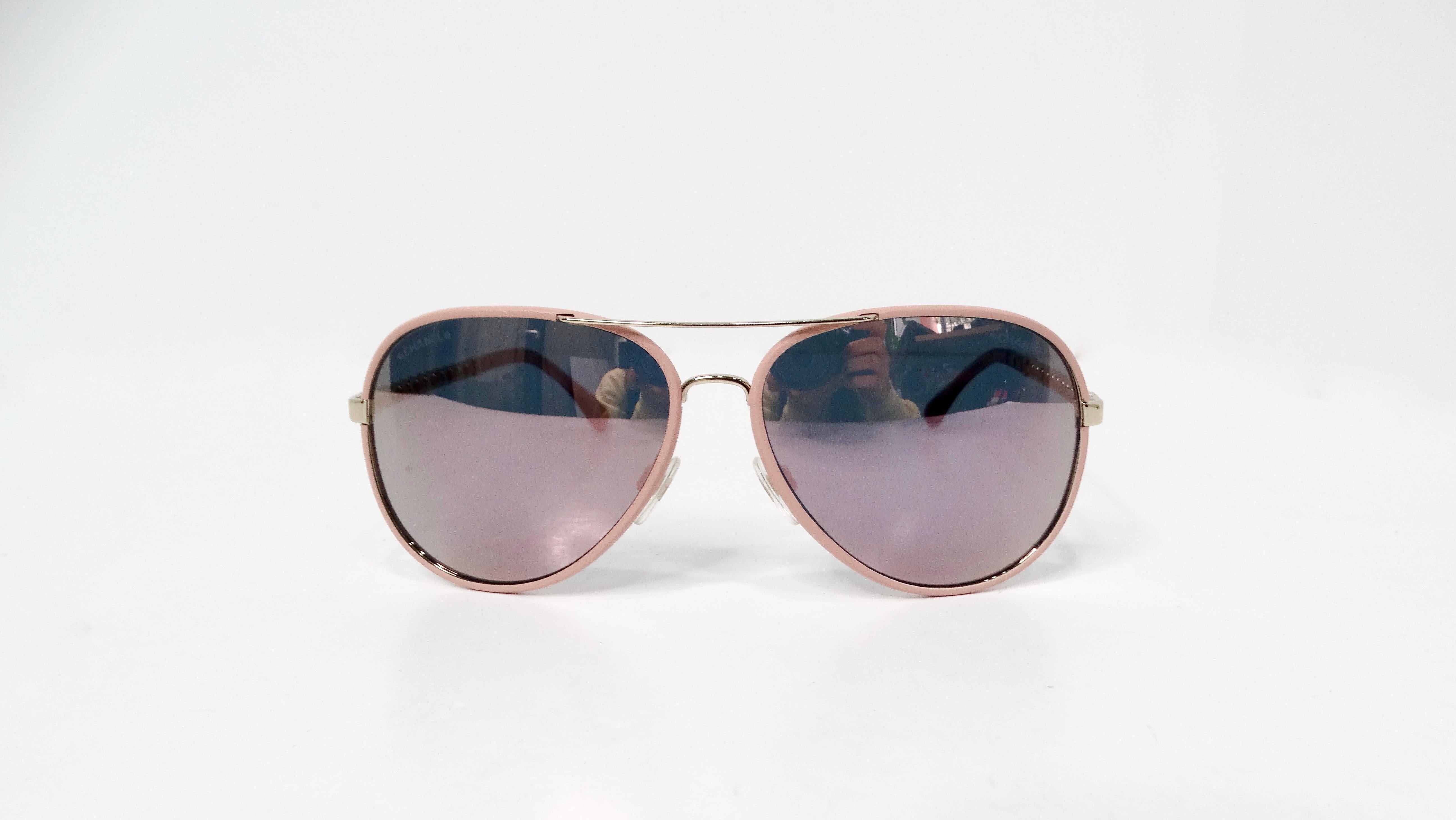 Elevate your winter wardrobe with the chic and sophisticated Chanel Light Pink Metal Polarized Pilot Aviator Sunglasses, a stunning accessory that blends style and functionality. These expertly crafted sunglasses feature light pink frames and