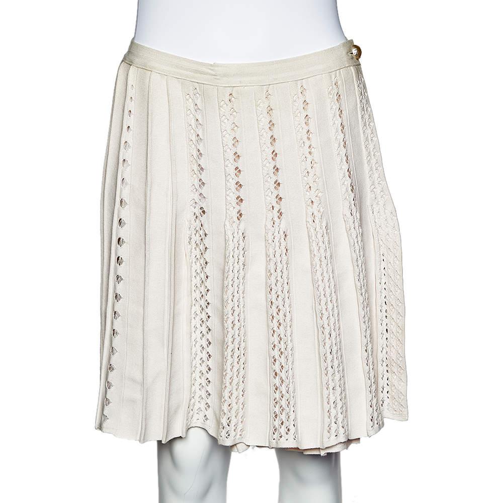 Experience the charm of designer clothing with this gorgeous skirt from Chanel. Made from quality knit fabrics, the skirt has a faux-wrap style, perforated pattern, and buttoned closure. Pair it up with a tailored blouse or a simple top and high