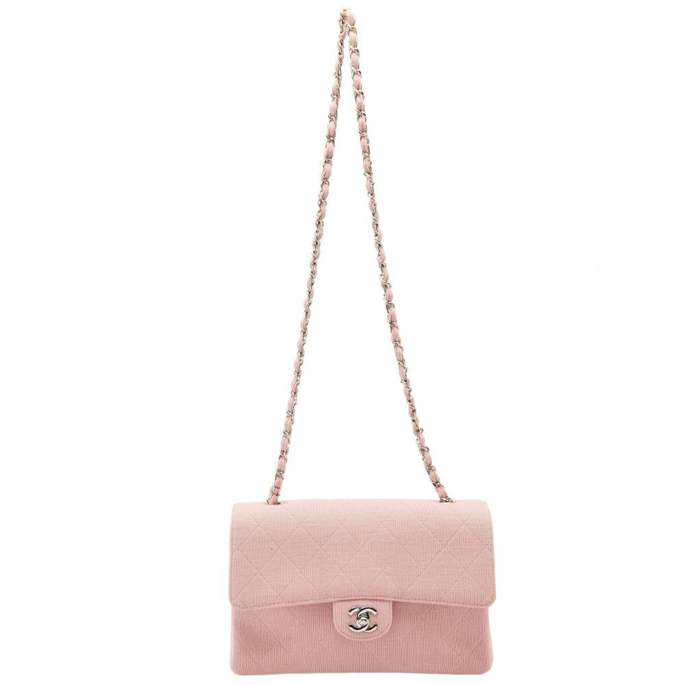 Chanel's Flap bags are the most iconic handbags. The classic single flap bag is crafted from light pink jersey and features the iconic quilted pattern. It has a chain and jersey woven strap along with a CC twist lock closure in silver tone. The flap