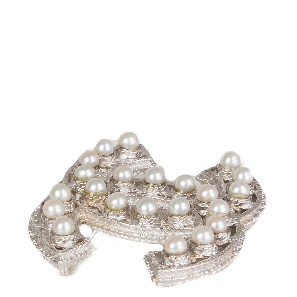 Broche Chanel 'CC' en métal argenté clair rehaussée de fausses perles blanc cassé. A été porté et est en excellent état. 

Largeur 5cm (2in)
Hauteur 4cm (1.6in)
Profondeur 0,5cm (0,2in)
Quincaillerie en métal argenté
