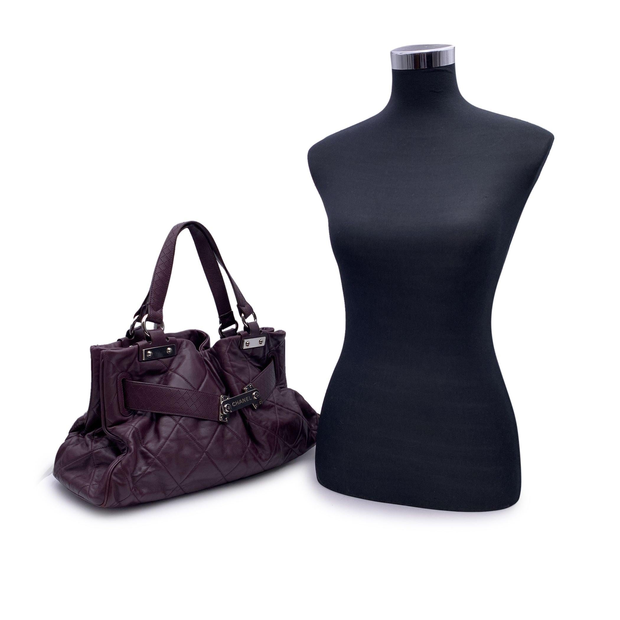 Chanel Limited Edition 'Paris-Londres' satchel bag. Period/Era: 2008. Silver metal hardware. Purple quilted leather. It features double leather handles, latch closure on the front and silver metal hardware. Gray satin lining. 1 side zip pocket and 2