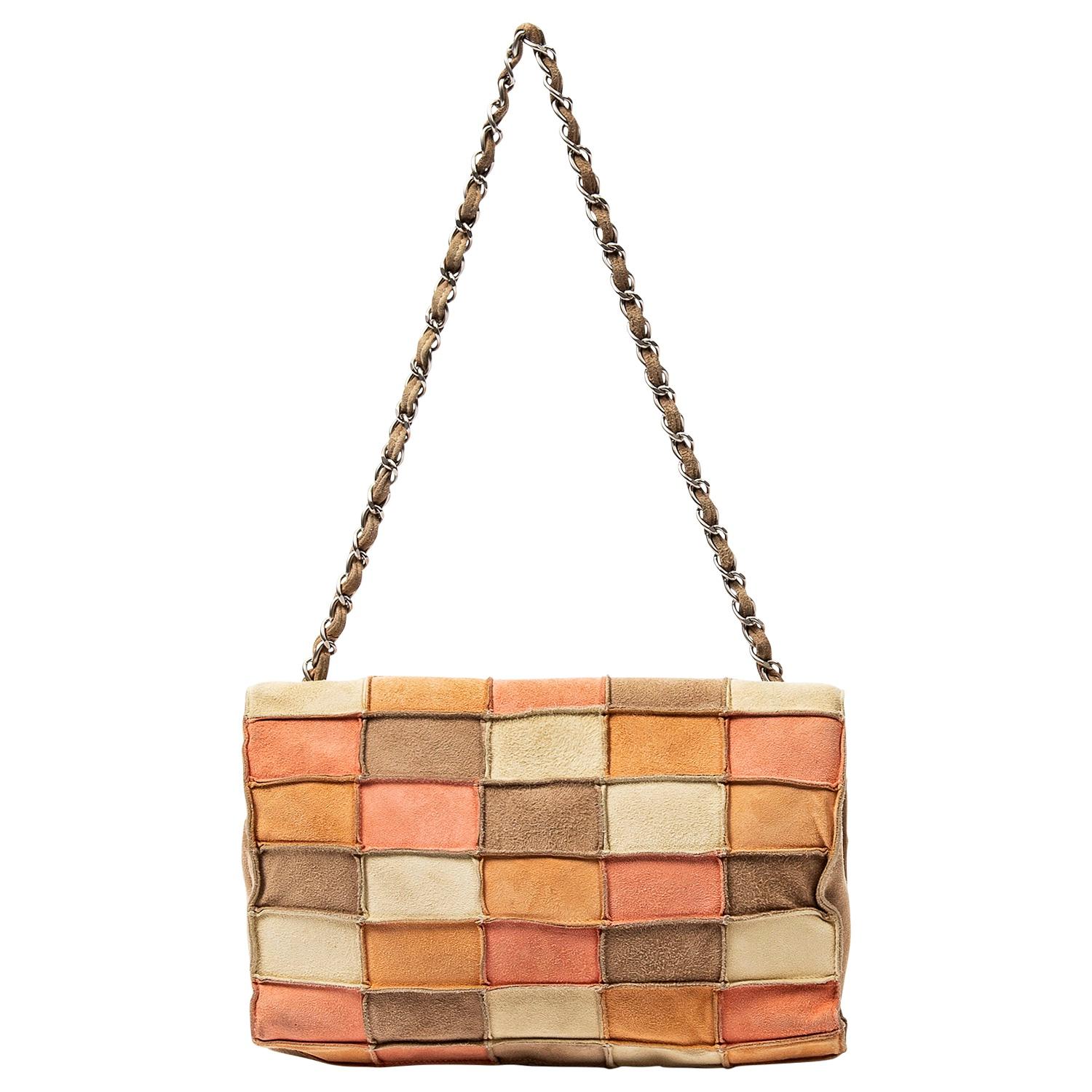 We love this late 90s beauty with a cool nod to mid century modern vibes with its fun patchwork motif! This is a trendsetting limited piece that is a vintage collectors dream. Crafted in peach/beige/ivory/multi suede with brushed silver-tone