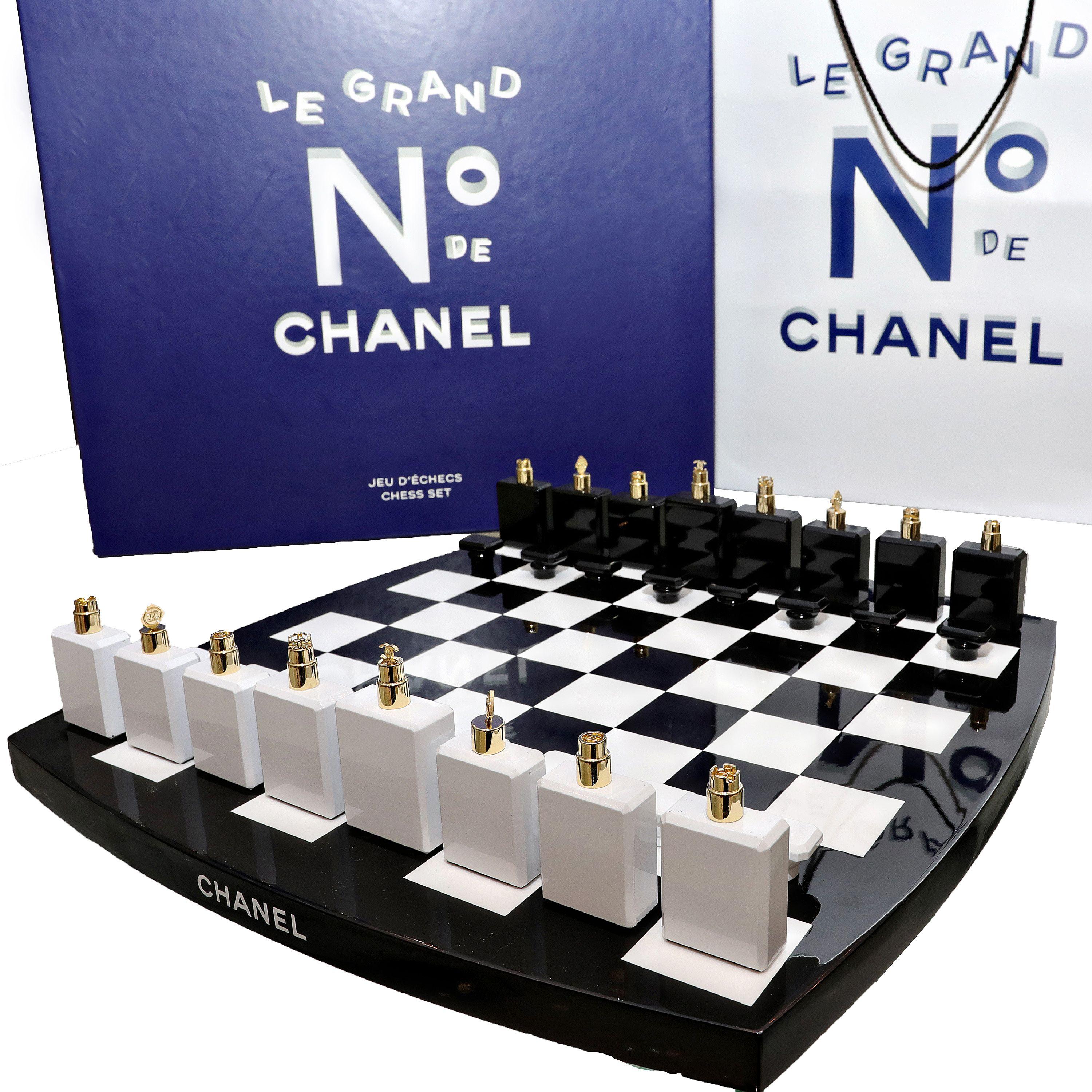 This authentic Chanel Limited Edition Chess Set is in pristine condition.  A must have for any collection.  Black and white lacquered chess board with Chanel No 5 perfume bottles acting as the chess pieces.  The toppers on each “bottle” indicate the