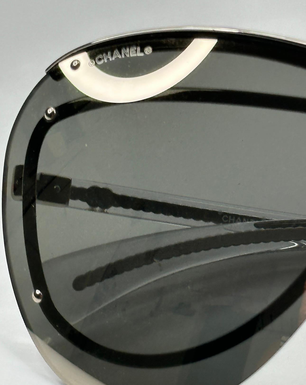 Chanel 'Limited Edition' mirrored silver-chrome finish accented with chrome studs space-age sunglasses features curved arms for a better fit and measures 5 1/4 inches in length. The front measures 5 1/2 inches across, height is 2 1/2 inches. Arms