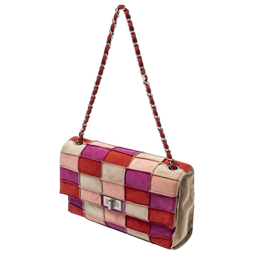 We love this late 90s beauty with a cool nod to mid century modern vibes with its fun patchwork motif! This is a trendsetting limited piece that is a vintage collectors dream. Crafted in pink/multi suede with brushed silver-tone hardware and a sleek