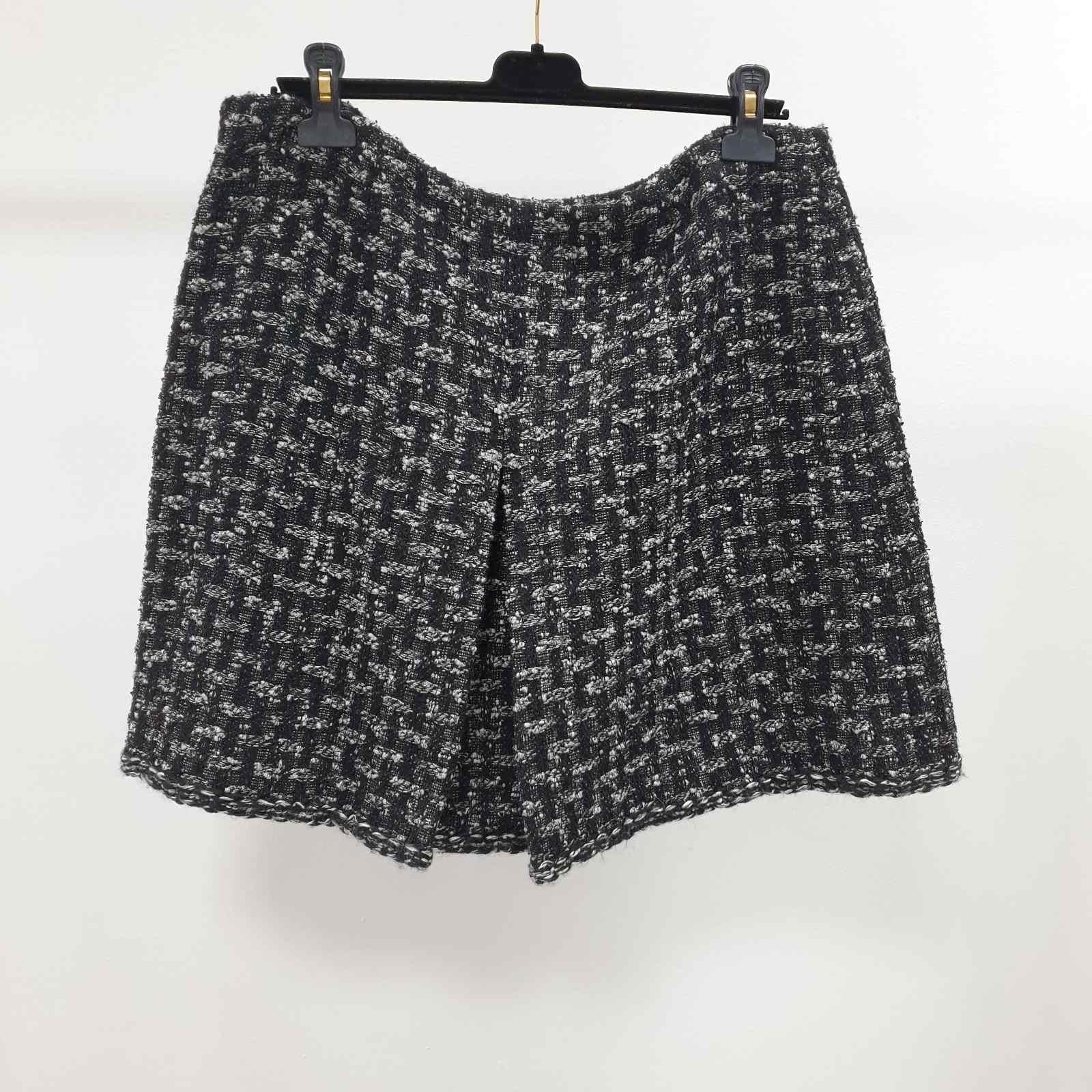 Jupe jupe doublée noir/gris en laine mélangée.  Article noir/gris complété par un échantillon de matériau supplémentaire  et le bouton Icone CC. 36 % laine, 27 % polyester, 18 % coton, 12 % rayonne et 7 % polyamide.  La doublure est 100% soie. La