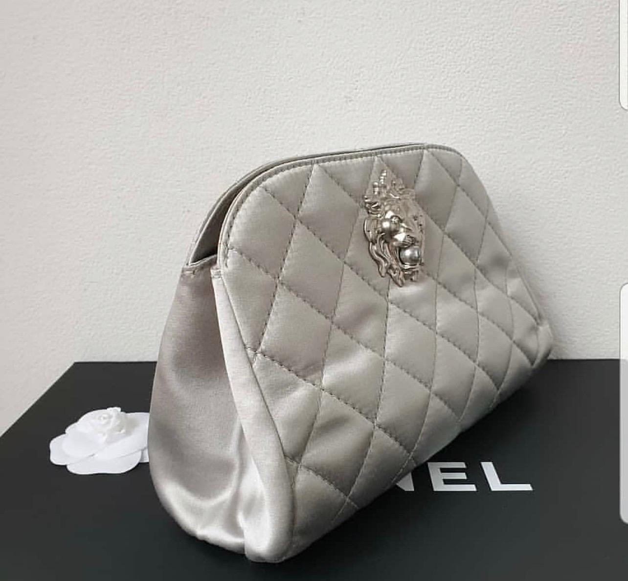 This authentic Chanel Leo Lion Clutch Quilted Satin Small presented in the brand's Cruise 2010-2011 Collection inspired by Coco Chanel's sign is an elegant accessory made for a formal night out. Crafted from diamond quilted silver satin, this mini