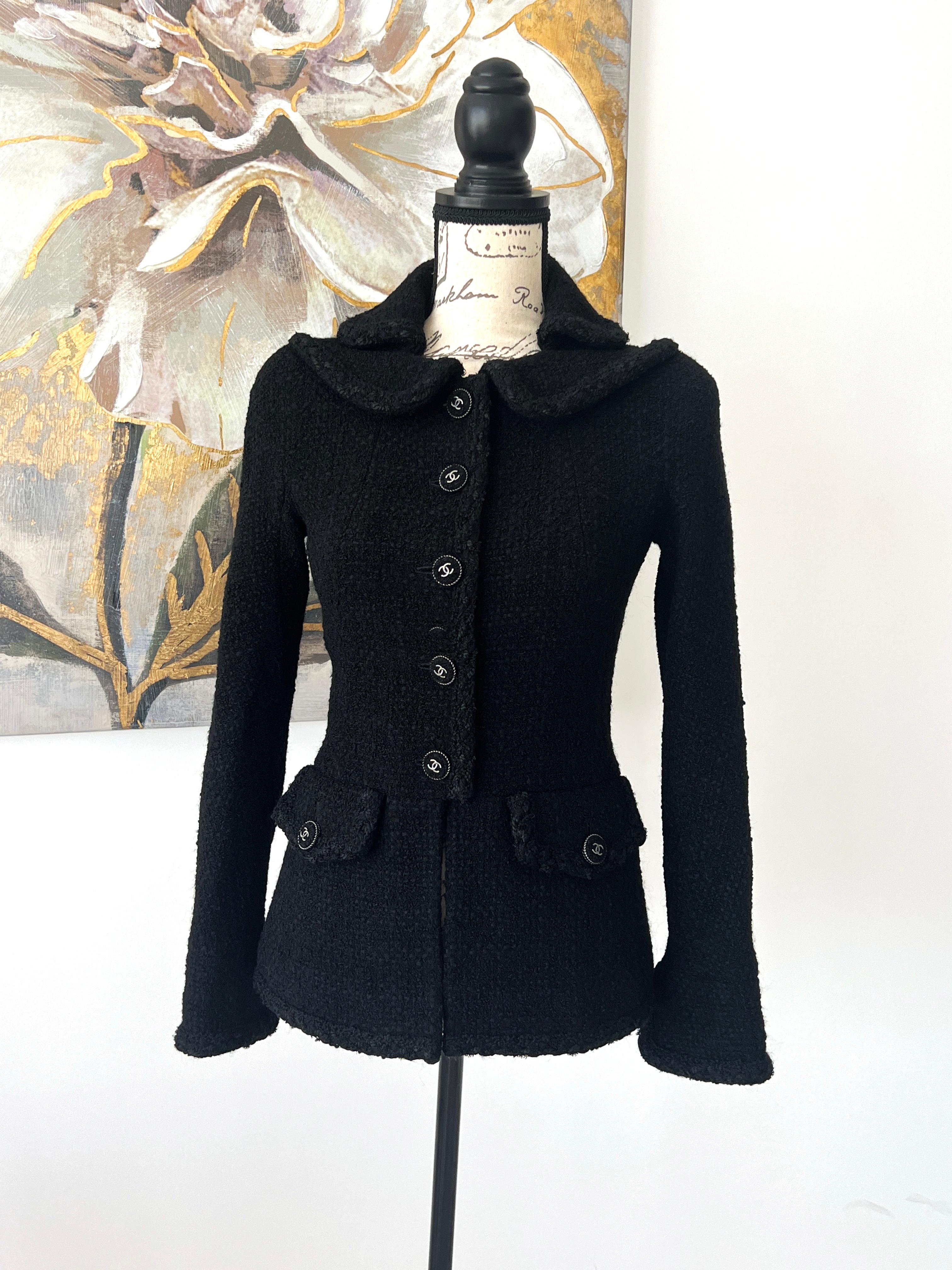 Iconic Chanel black tweed jacket from Paris / EDINBURGH Collection.
- signature braided trim
- CC logo tweed buttons
- chain link at hem, Full silk lining with Camellias
Size mark 36 fr. kept unworn.