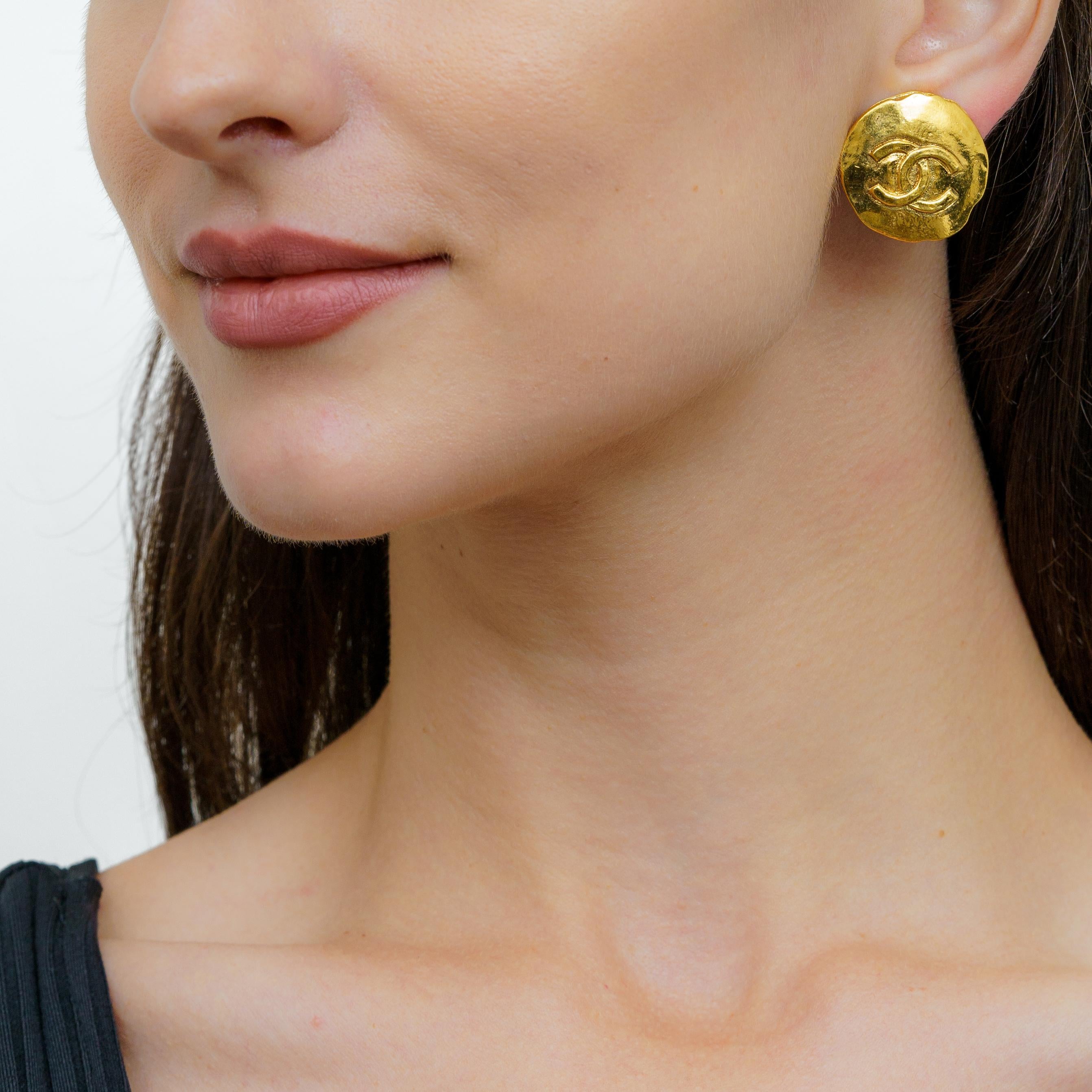 Diese eleganten und luxuriösen Chanel Logo-Knopf-Ohrringe verleihen jedem Look einen Hauch von Raffinesse. Diese Ohrringe sind aus vergoldetem Metall gefertigt und mit dem ikonischen Chanel-Logo verziert. Sie sind ein echter Hingucker. Mit ihrem