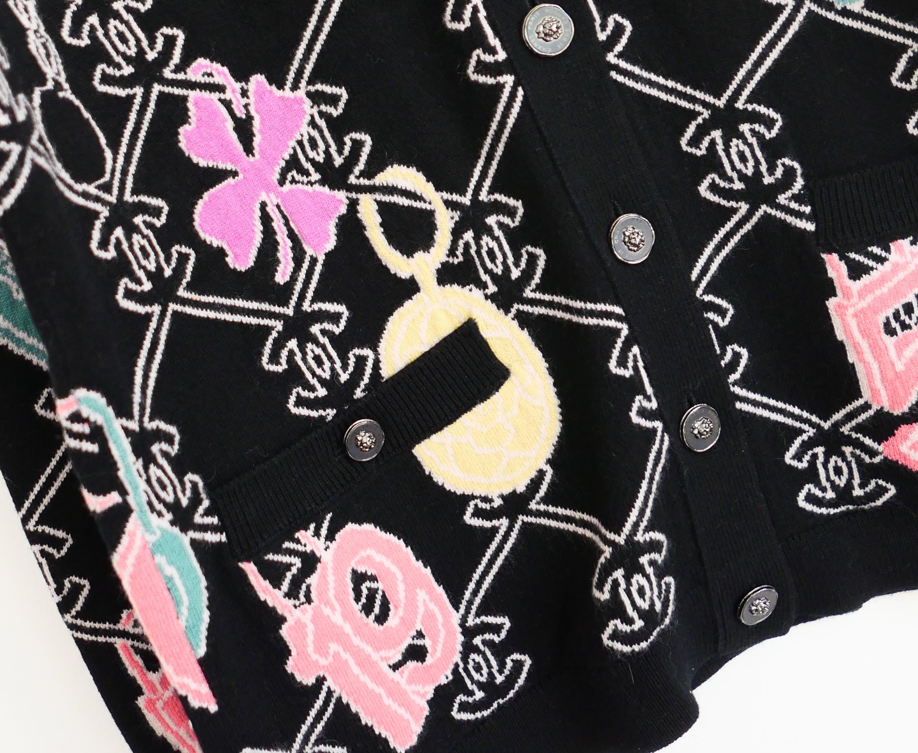 Étonnant cardigan en cachemire à logo Chanel de la collection Printemps 2022 22P. Neuf avec étiquette, fil et 2 x boutons de rechange. Elle est réalisée en cachemire tricoté avec logo noir et blanc, avec un motif en forme de breloque de couleur